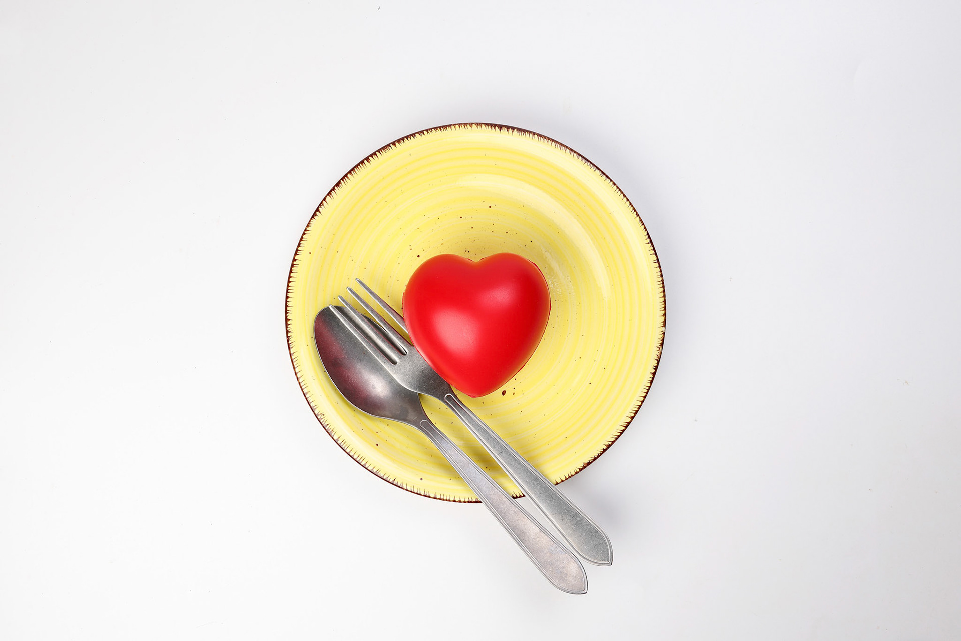 ceramic retro yellow food plate fork spoon with three dimension 3d red hart symbol on top of it white background copy text space top view