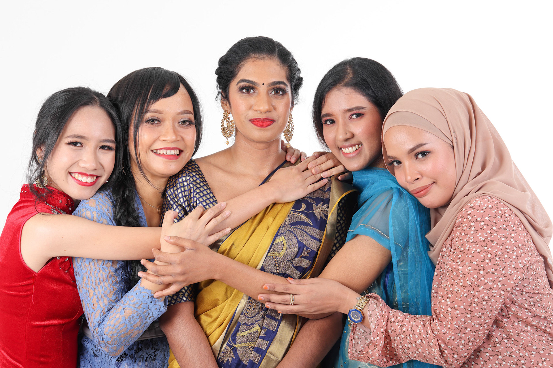 South east Asian Malay Chinese Indian race ethnic origin woman wearing dress costume baju kurung cheongsam samfu kebaya Sharee multiracial community on white background happy smile hug togetherness
