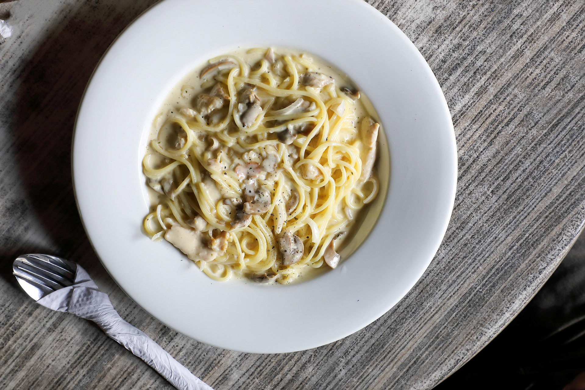 Spaghetti with creamy mushroom sauce in a plate on rustic table