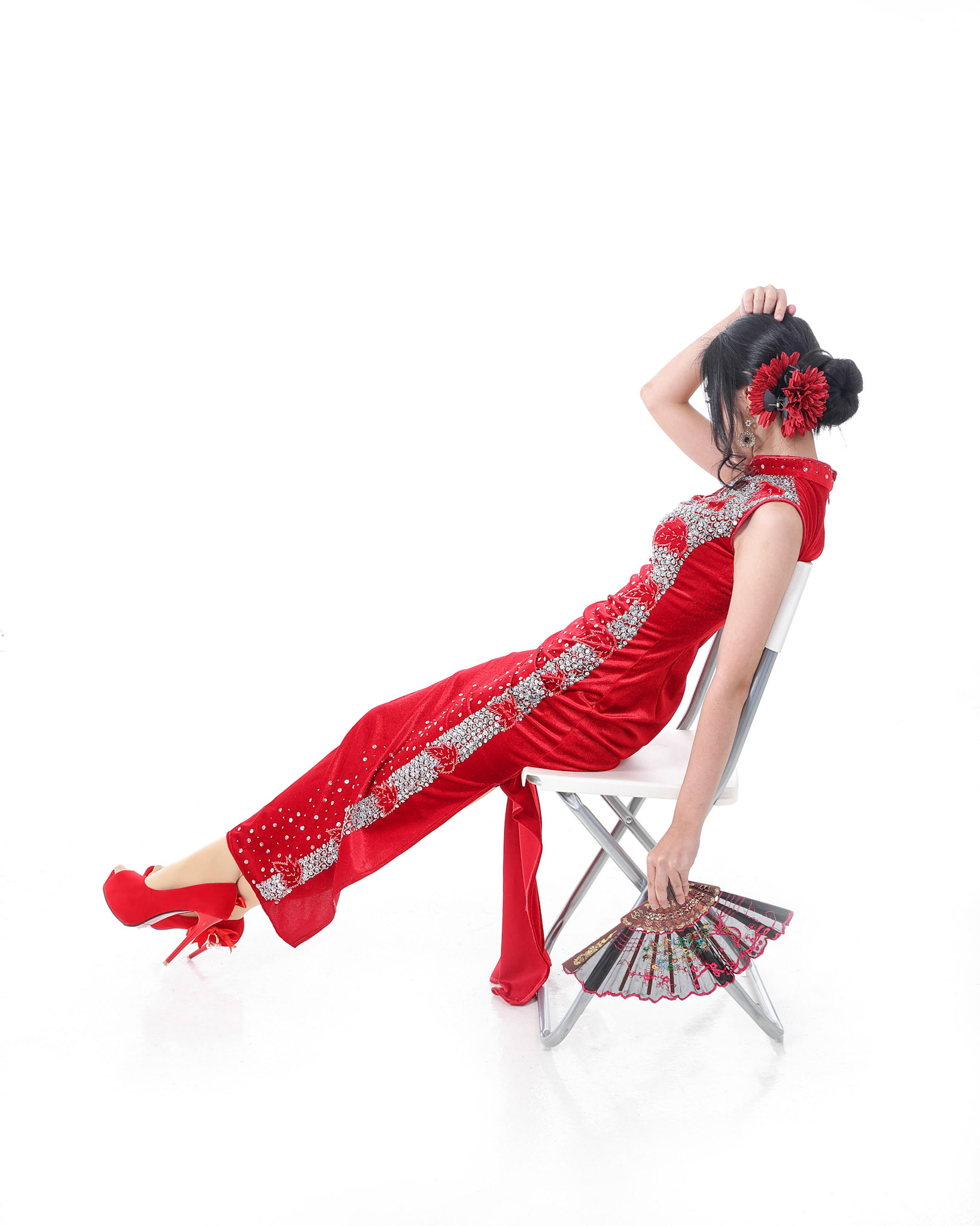 South east Asian Chinese race ethnic origin woman wearing red velvet cheongsam with hand stitched sequence work dress costume hand fan on white background