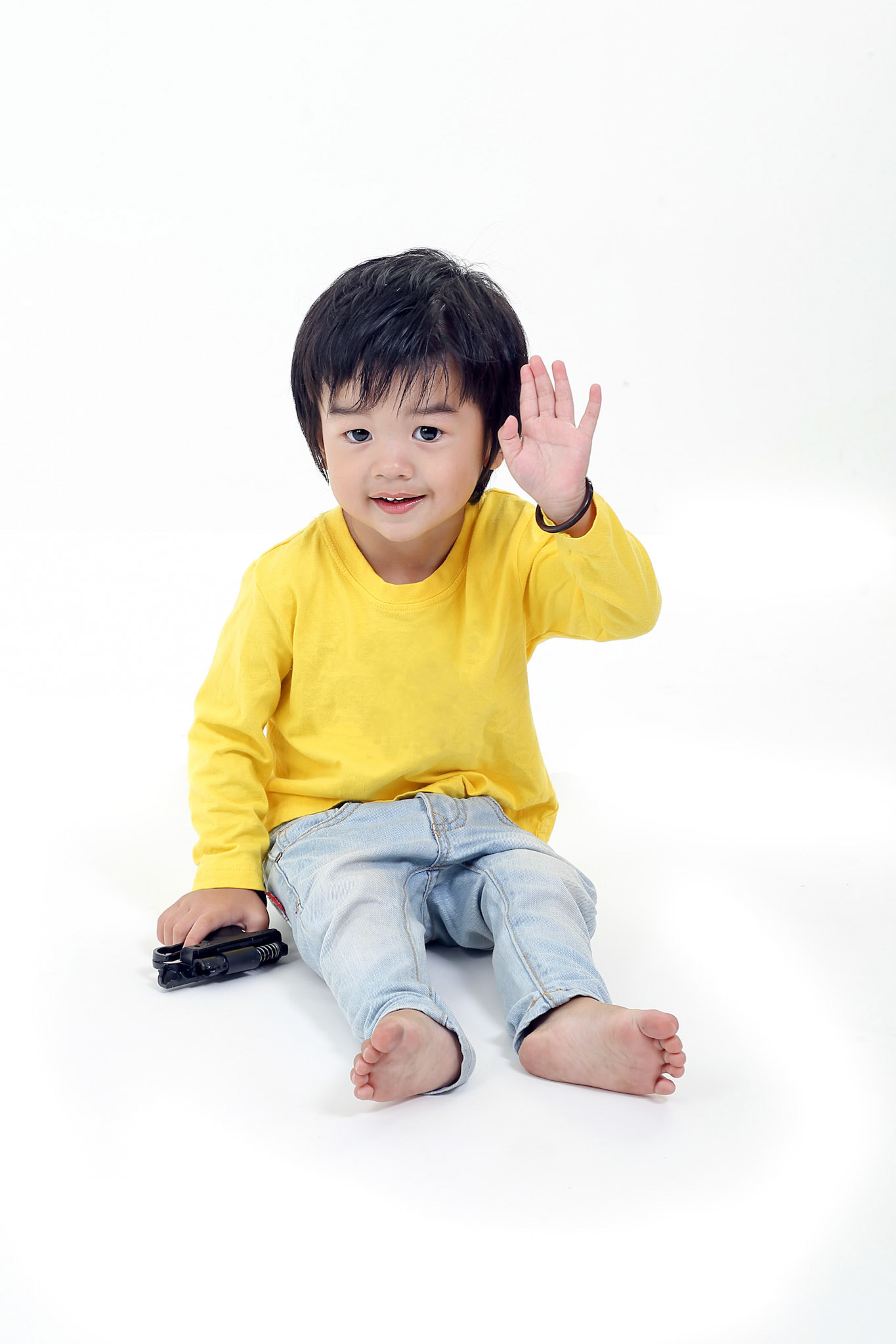 South East Asian young boy child playing happy waving hand at camera on white background