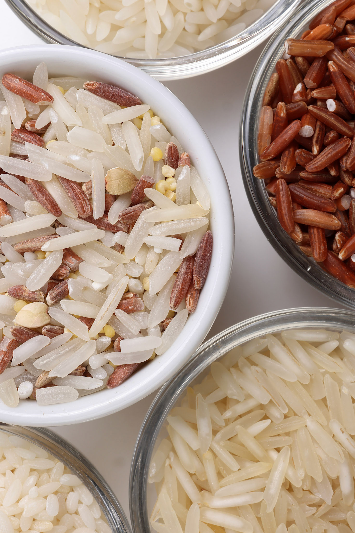 Long grain basmati medium grain jasmine short grain pilaf polau risotto brown low glycaemic index gi rice in small glass bowl on white background copy text space top flat lay view