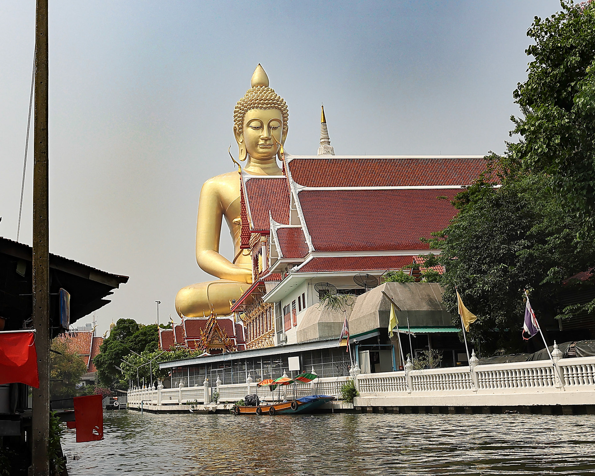 Bangkok, Thailand April 11, 2024- The Royal Wat Paknam Phasi Charoen temple, the 69 meter tall Buddha idol seen from canal.