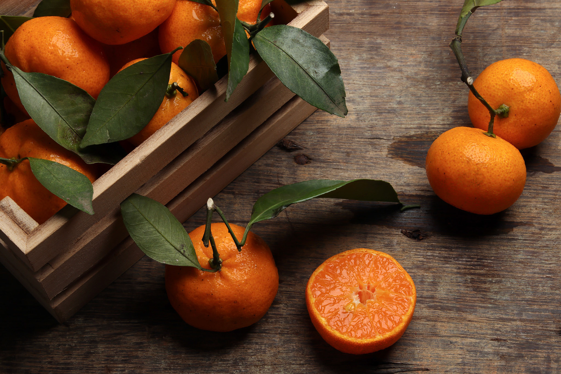 mandarin orange green leaf wood crate box on rustic wooden background