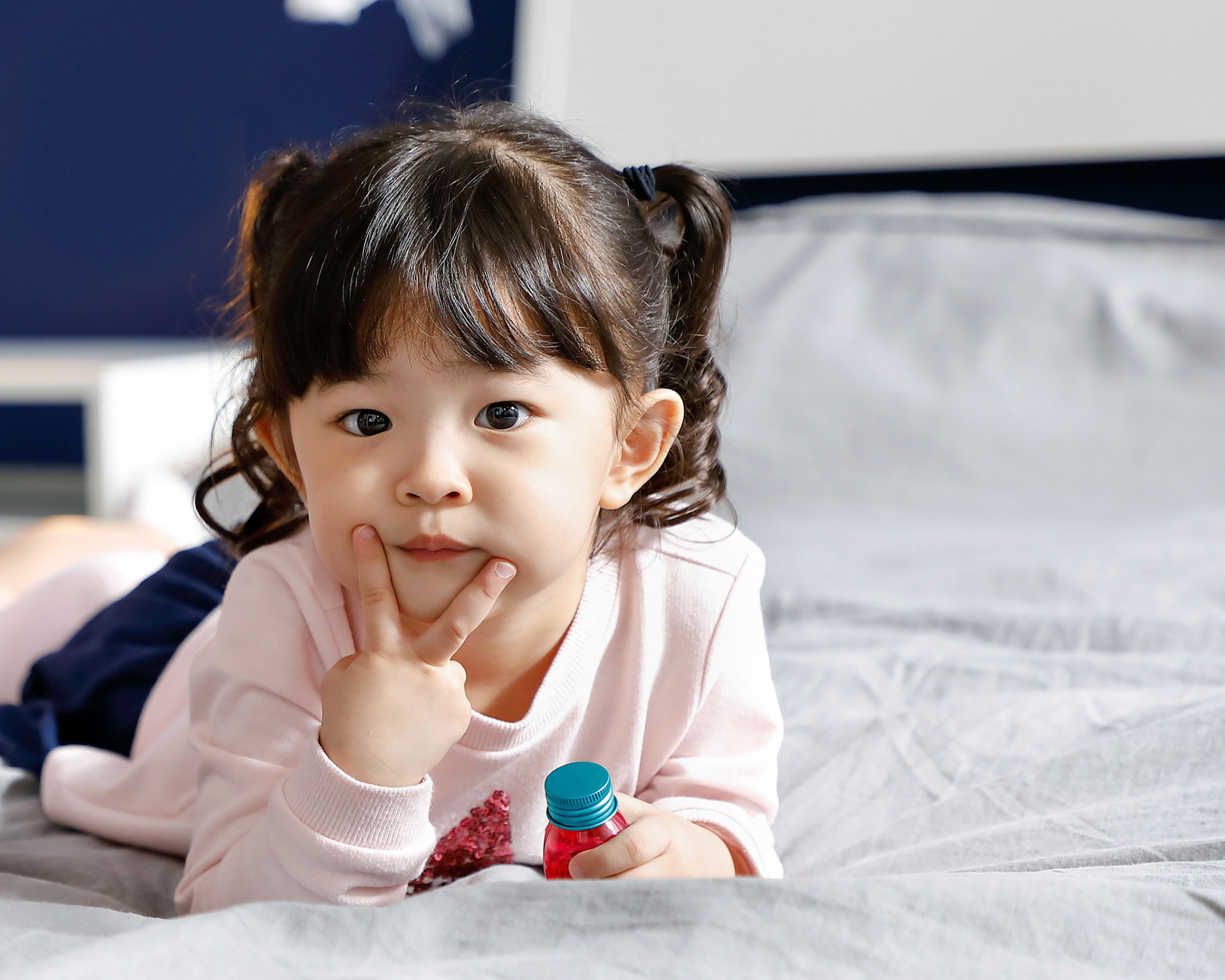 One girl children lying on bed looking forward posing