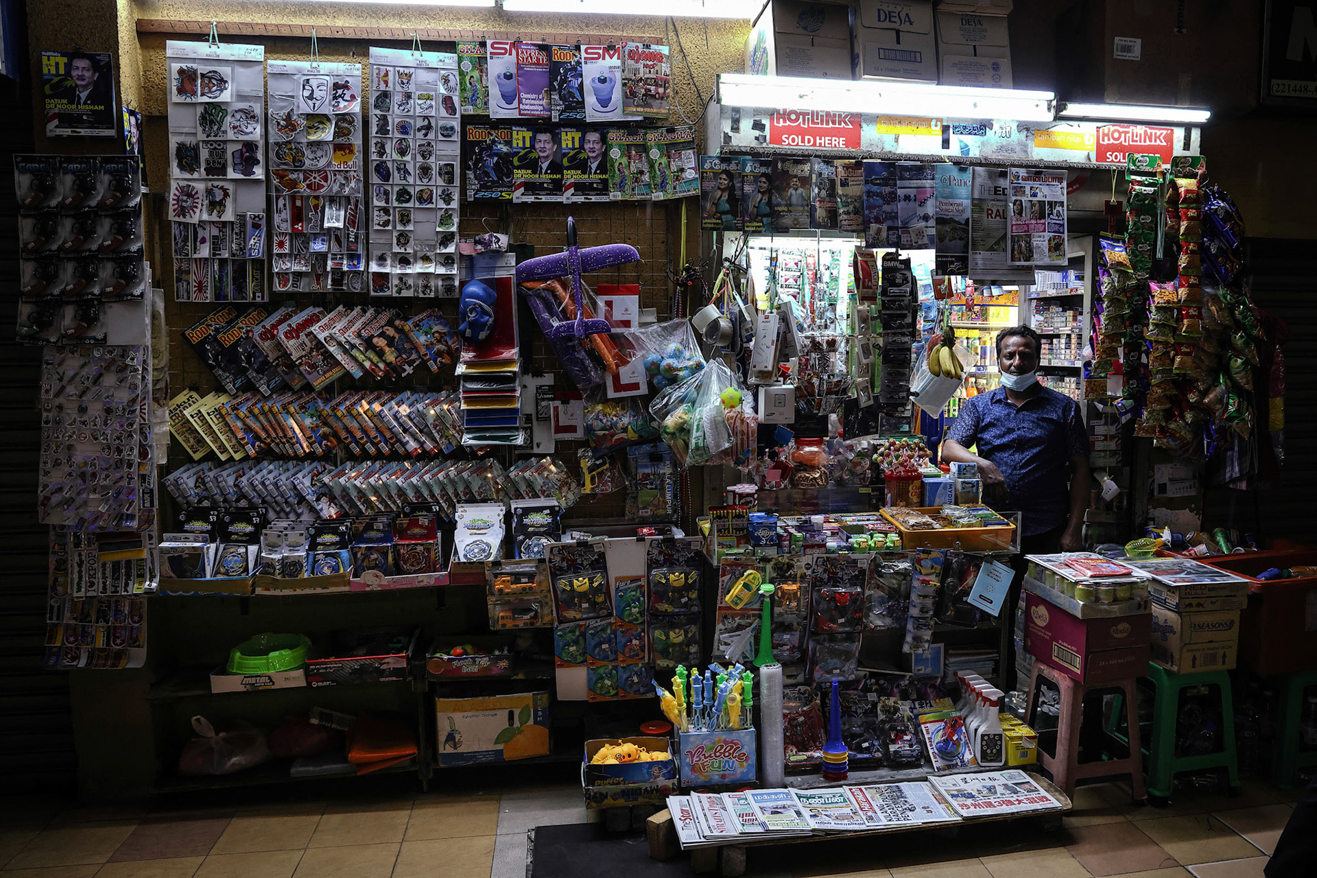 Kuala Lumpur, Malaysia-September 11, 2020- A owner of street side in the wall convenience store looks on in the evening, slow struggling market in covid-19 pandemic