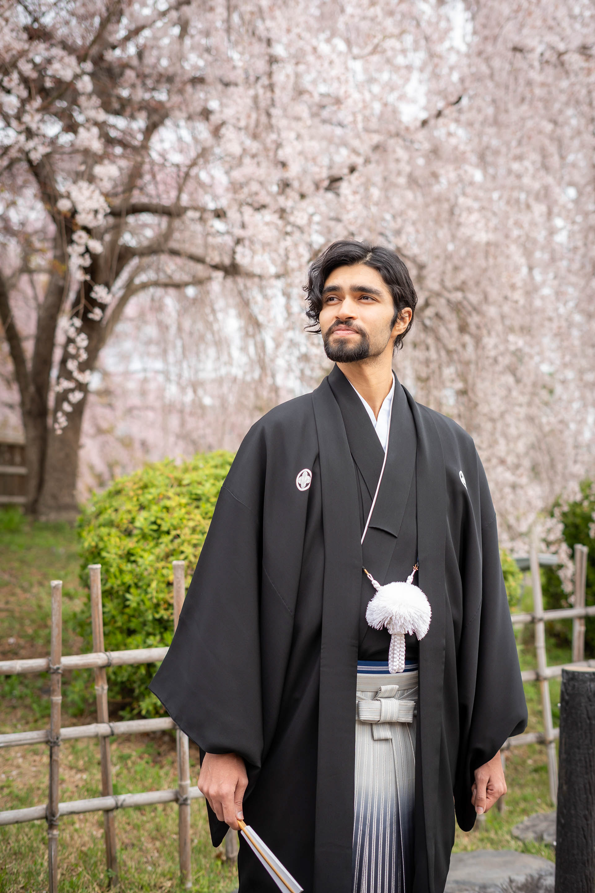 Paren Creates portfolio picture in kimono in front of cherry blossom trees in Kyoto