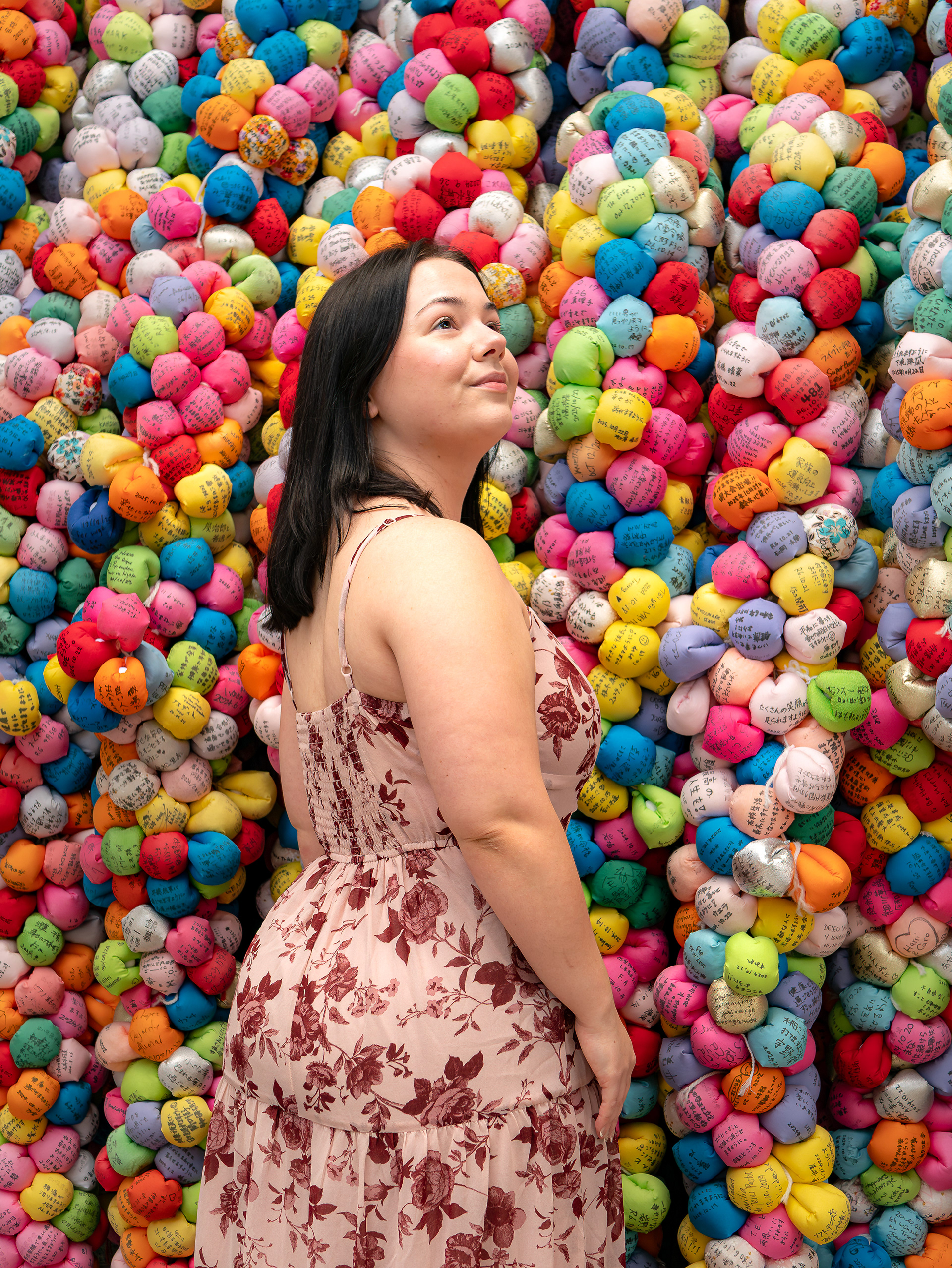 Kyoto cinematic photoshoot by Paren Creates featuring an American solo traveler in a floral dress at a colorful shrine filled with wishing balls near Hokan-ji Pagoda