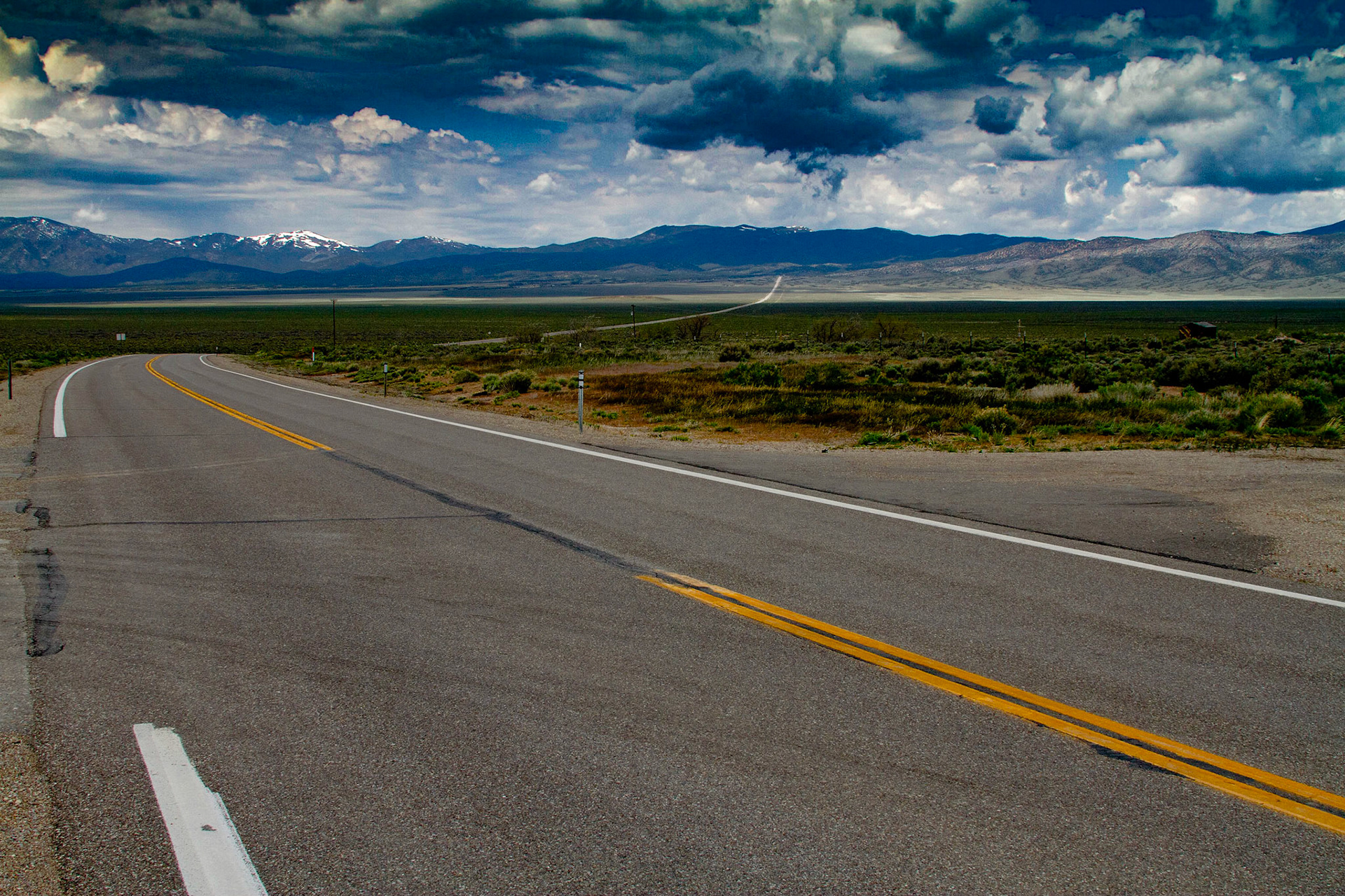 I found a historical marker for Osceola along Highway 50, which indicated a gold-bearing quartz belt was found in 1872.  It turned out to be 12 miles long and 7 miles wide with depths ranging from 10 to 200 feet.  Mining continued until 1940, with some intermittent mining still continuing.  There were two possible dirt roads onto the mountain to the east of the intersection, but no indication of the distance to an abandon town.  Osceola was not identified on the map I was using.  I took a few pictures in that area, including a storm coming across the mountains to my west.  Then I proceeded toward Great Basin National Park on Highway 50.  After several miles, there was a direction sign for Osceola which indicated just 7 miles by a different route.  I followed that road through a high mountain pass back to the same historical marker.  Along the way I saw a lot of abandon or almost abandon mining operations with decaying equipment and an old cemetery high on a point overlooking the valley.  The view of this valley from high on that mountain was impressive.