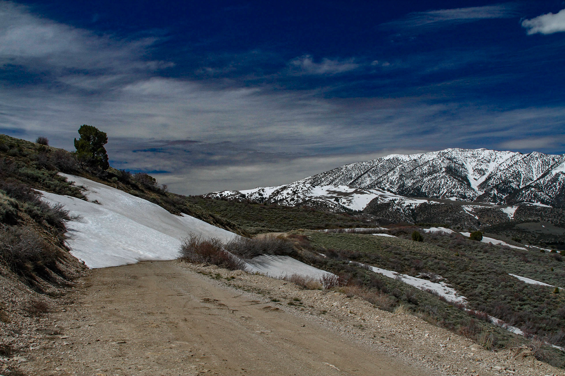 Halmiton Nevada, The First Snow Drift that Stopped Me, May21, 2011 -  A place that had my imagination from early in researching this tirp was Hamilton.  When I found the road, it was a good dirt route and remained so for a good while.  Rounding a bend, I realized I was near the snow line on another mountain across the valley. After a few pictures from there, I moved on.  Then, I rounded a bend to find a snow drift higher than the car across the road.  Walking back to get a shot of the car and the drift, I noticed a rougher road that seemed as though it may by-pass the drift. I tried it, but soon came to a long muddy portion that I decided I should not try.  Then, I saw a traveled trail back to the main road passed the big drift, but before a drift I probably could have navigated.  I decided not to try it, because climbing back up to where I was may have been problematic.  Later I realized there were probably more drifts before Hamilton.  Later in the day I proved it.