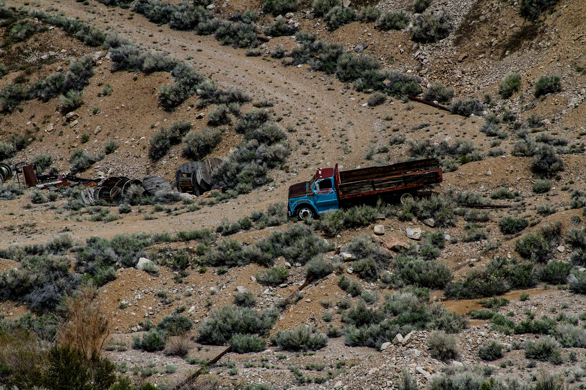 I found a historical marker for Osceola along Highway 50, which indicated a gold-bearing quartz belt was found in 1872.  It turned out to be 12 miles long and 7 miles wide with depths ranging from 10 to 200 feet.  Mining continued until 1940, with some intermittent mining still continuing.  There were two possible dirt roads onto the mountain to the east of the intersection, but no indication of the distance to an abandon town.  Osceola was not identified on the map I was using.  I took a few pictures in that area, including a storm coming across the mountains to my west.  Then I proceeded toward Great Basin National Park on Highway 50.  After several miles, there was a direction sign for Osceola which indicated just 7 miles by a different route.  I followed that road through a high mountain pass back to the same historical marker.  Along the way I saw a lot of abandon or almost abandon mining operations with decaying equipment and an old cemetery high on a point overlooking the valley.  The view of this valley from high on that mountain was impressive.