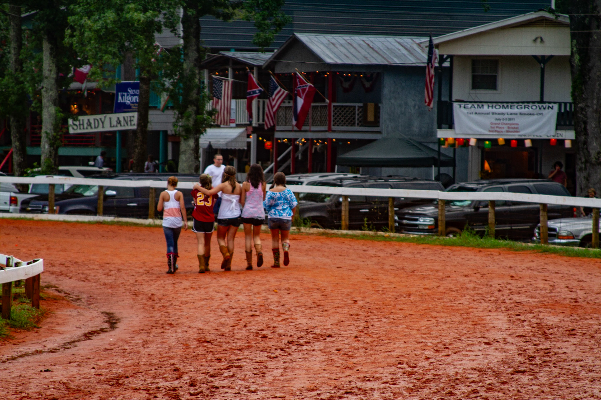 People walk the horse track in the early evening, even when it is very muddy.Second Day, Neshoba County Fair