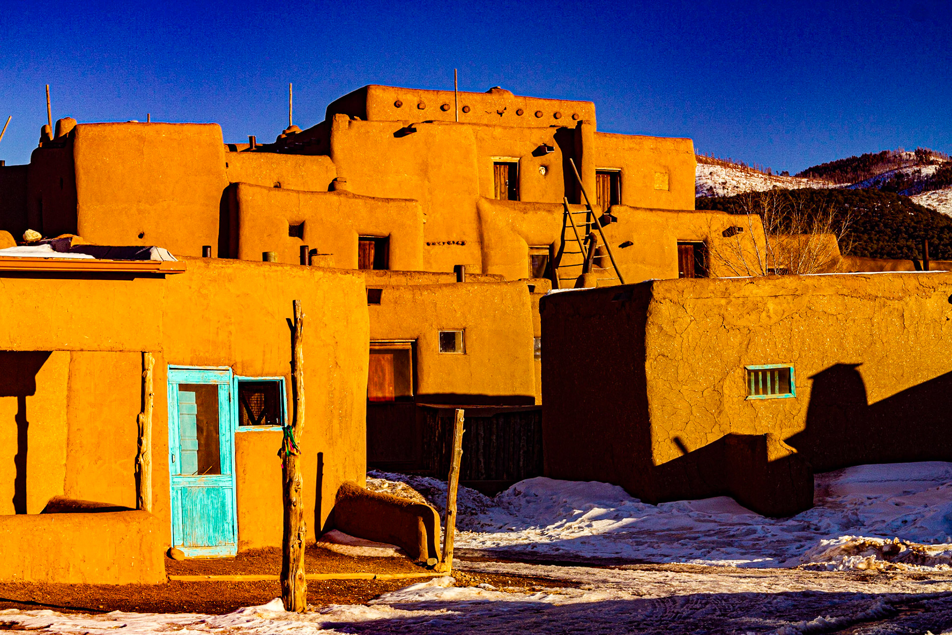 Taos Pueblo, where one of the large buildings still looks much as it did in the 1600s when conquistadors arrived, is a few miles north of Taos.  Native families still live there, without electricity or running water.  Ground level doors and windows have been added.  When the buildings were built, people climbed ladders to the roofs, to enter through holes there.  There were a few propane tanks. We visited with Debbie Lujan in White Flower Photography (http://www.rivertradingpost.com/Debbielujan.htm) and bought a couple of pottery mugs in another shop.  There were fees for entering the grounds and parking.  It cost $6 to carry my camera.