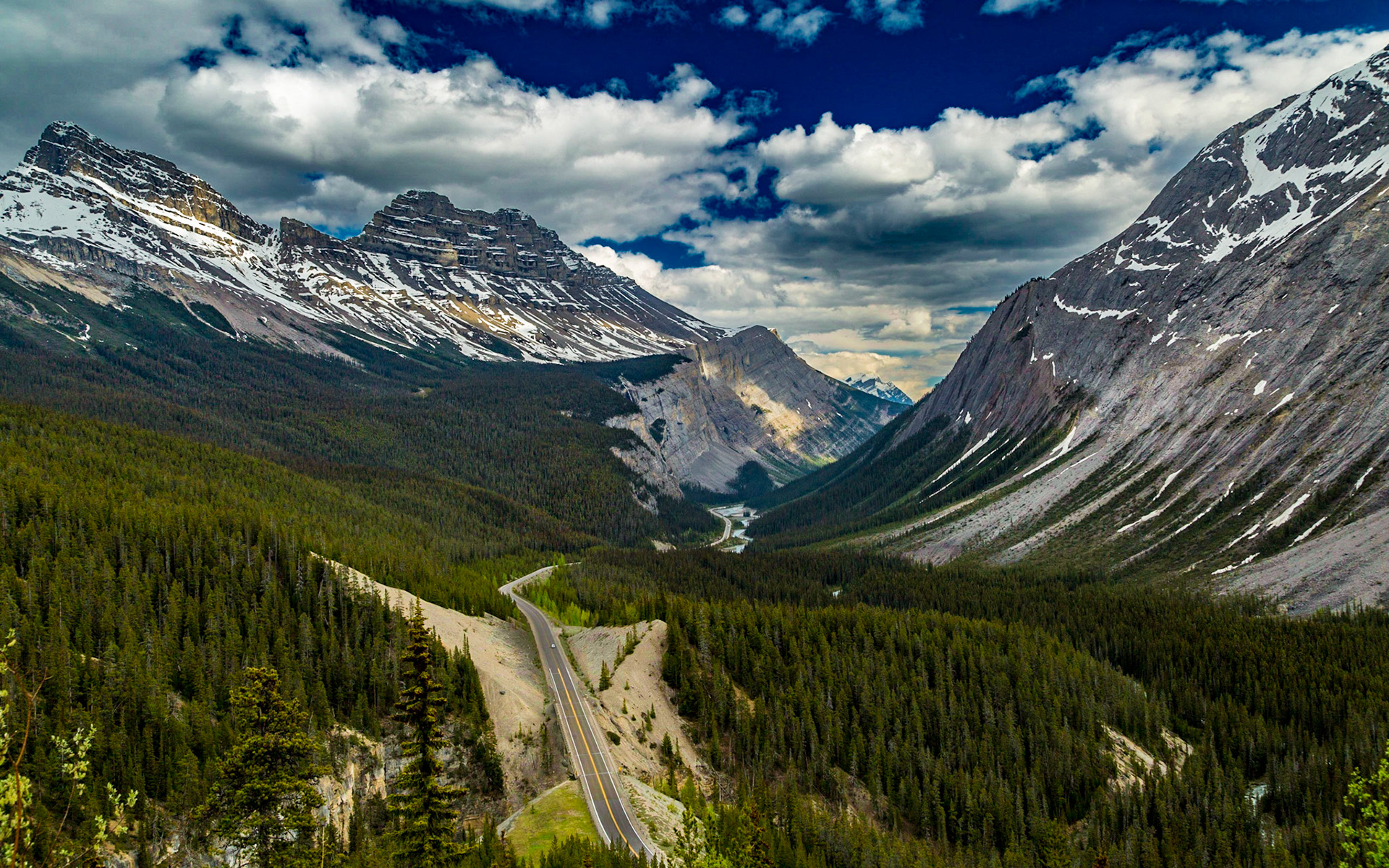 Leaving the Athabasca Glacier area, we realized we were approaching an overlook we had passed without time to stop the day before. This time, we approached it through a pass in Parker Ridge, instead of climbing a series of curves. This elevation is dramatically above the highway below. It is one of the more dramatic views of the trip.  Mark started the GoPro running in the pass, such that there should be a video reveal of this scene coming into view. The GoPro was attached to the windshield often during the trip.