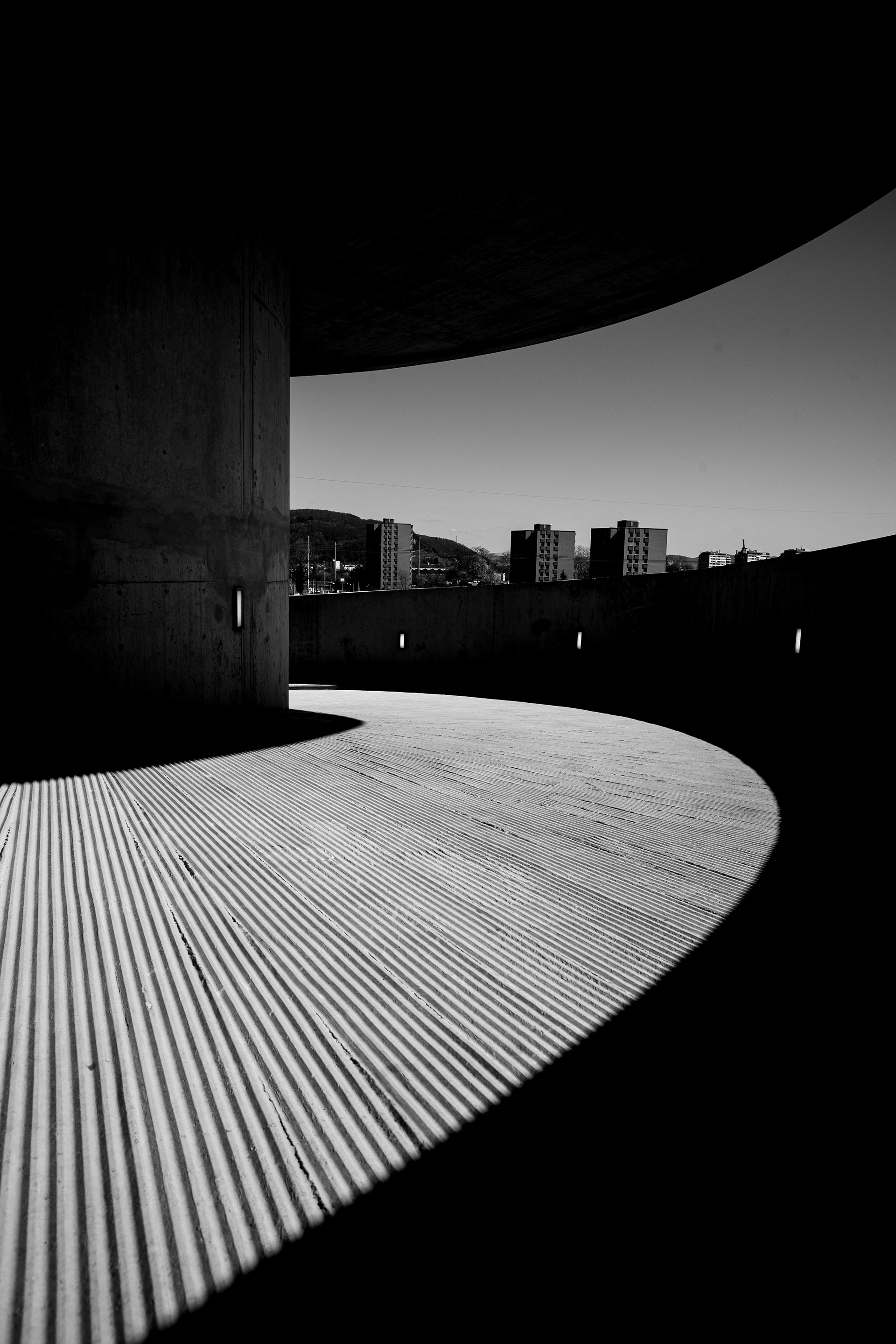 Minimalistic black and white architectural shot focusing on light and deep shadows in urban spaces. Photography by Carmine Castelli in Basel