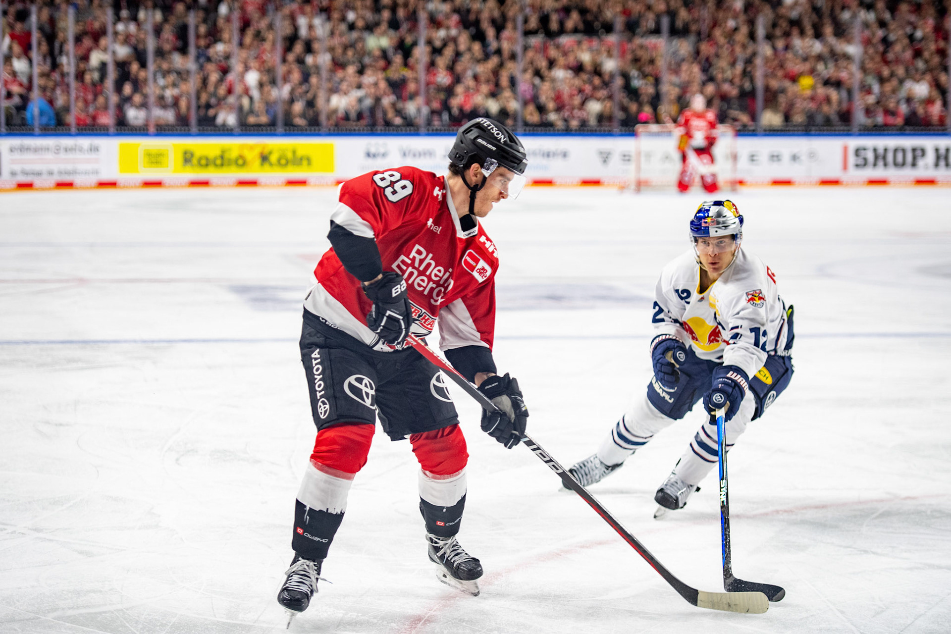 Benjamin Smith im Zweikampf mit Gregor Macleod; DEL Kölner Haie - EHC Red Bull München, 27.10.2023