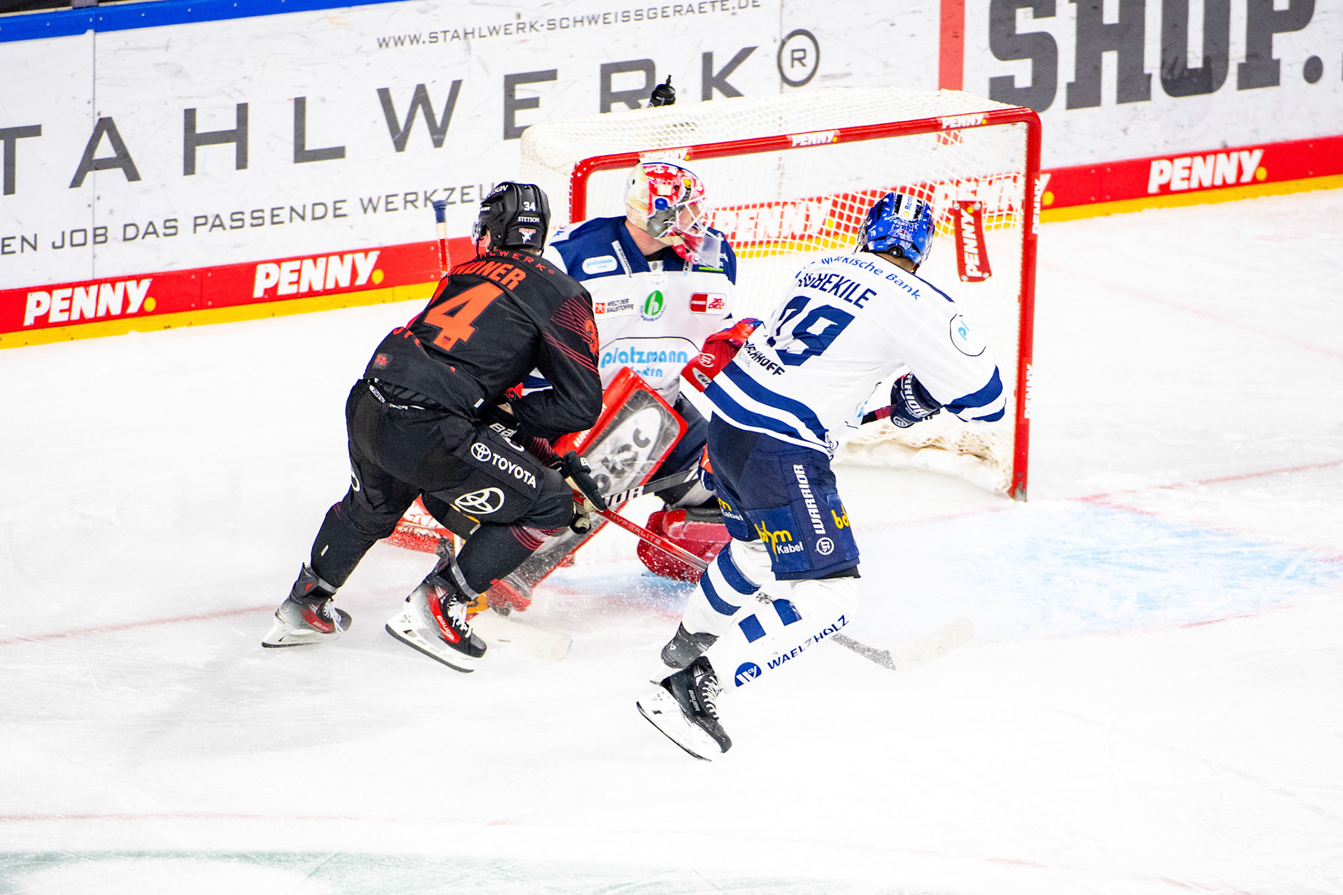 Elias Lindner im Kampf gegen Colin Ugbekile und Andreas Jenike; DEL Kölner Haie - Iserlohn Roosters, 02.01.2024