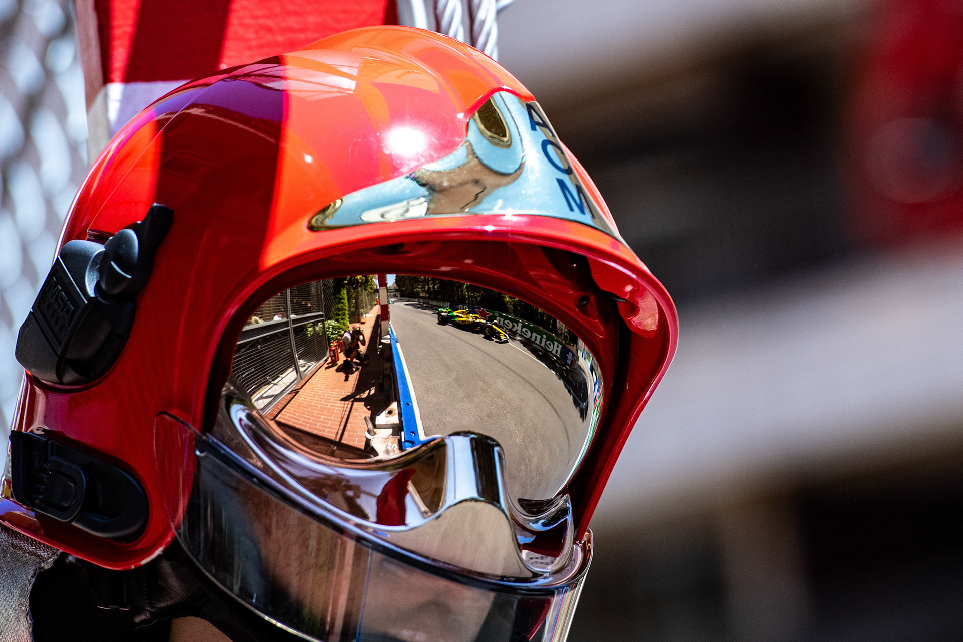 Mc Laren spiegelt sich in dem Helm des Feuerwehrmanns; Formel1 GP Monaco Samstag, 25.05.2024