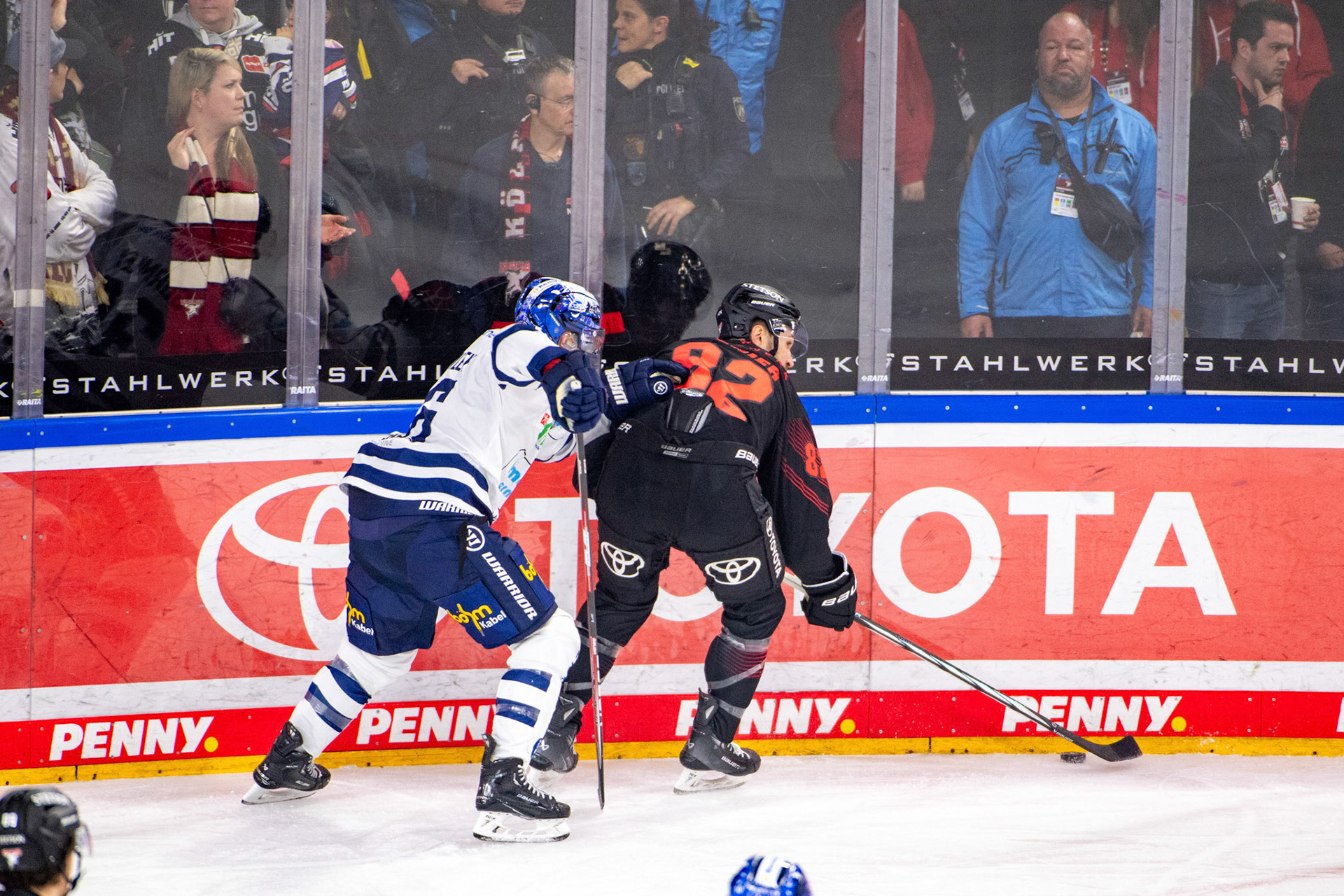 Brandon Gormley im Zweikampf mit Alexandre Grenier; DEL Kölner Haie - Iserlohn Roosters, 02.01.2024