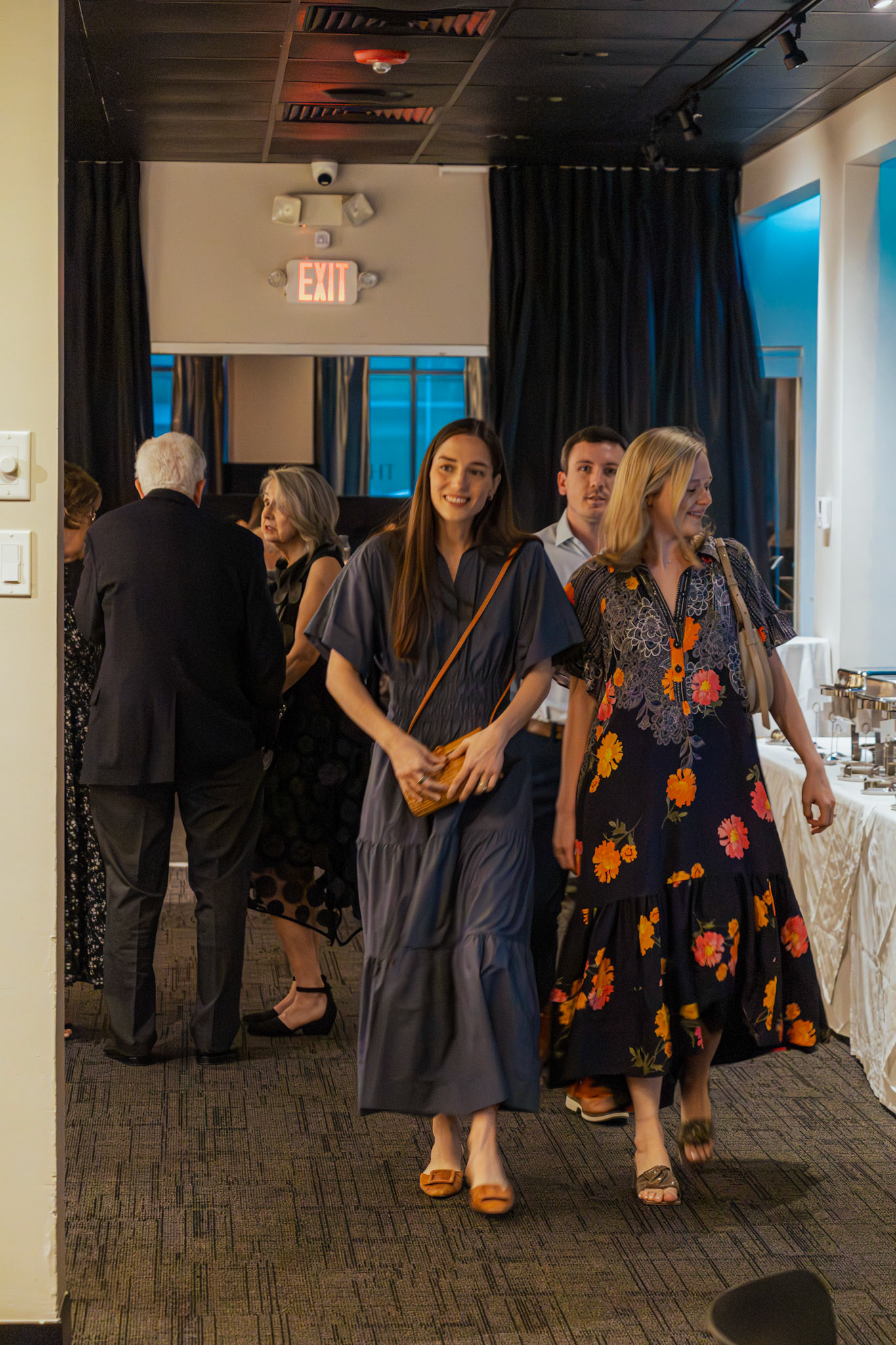 Smiling guests arriving to an atmospheric rehearsal dinner gathering at Theos in Pinnacle Hills, captured with a natural, editorial eye