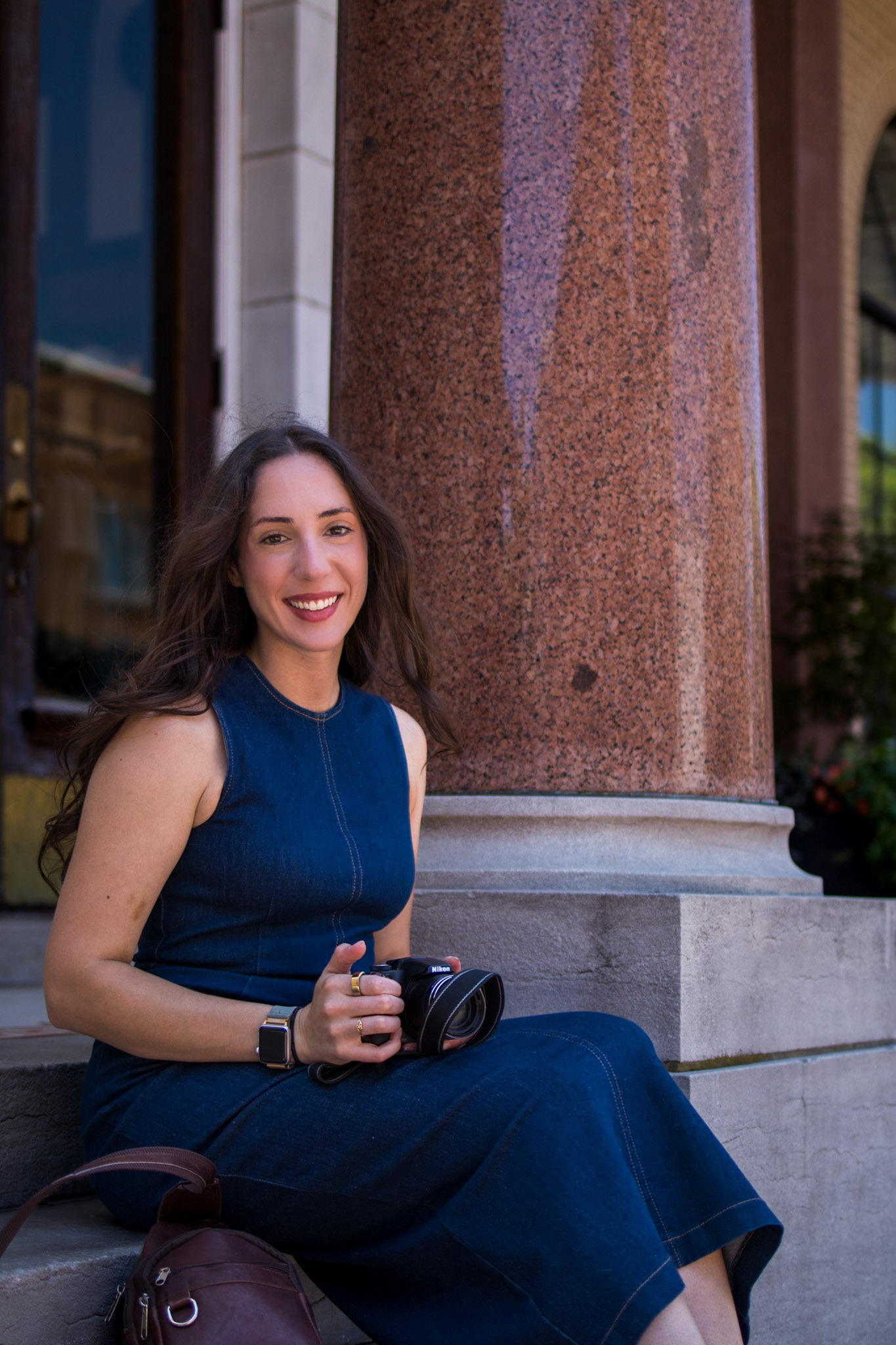 Colleen Vocque, an editorial photographer and fine artist based in Northwest Arkansas, holding a camera in a naturally lit setting.