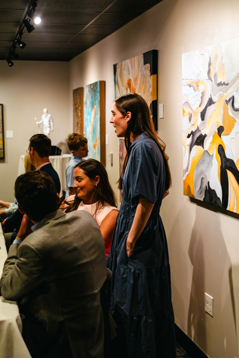 Guests mingling and celebrating during a Rogers, AR rehearsal dinner reception. Candid event photography capturing the warm atmosphere and genuine interactions.