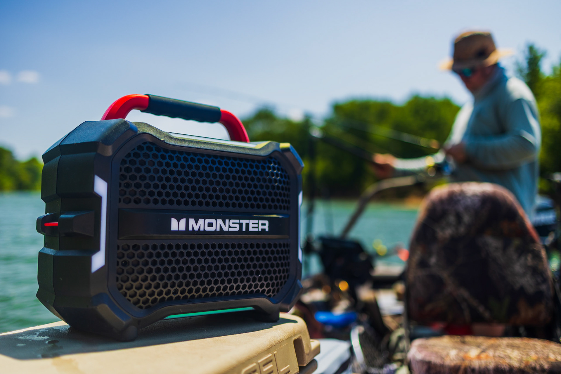A black waterproof Monster speaker floating partially submerged in water, demonstrating active product performance.