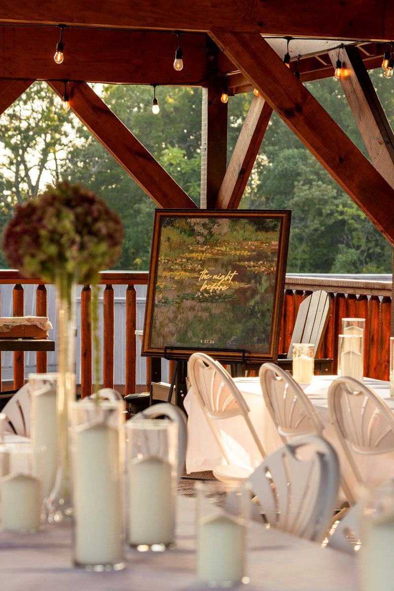 	Rustic elegance at a Sevierville, Tennessee rehearsal dinner venue. Custom "The Night Before" signage and detailed decor setup under a wooden pavilion. Event details and rehearsal dinner photography.