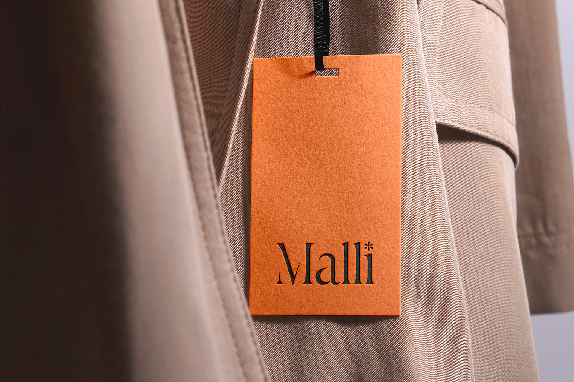 clothing tag against a beige coloured trench coat