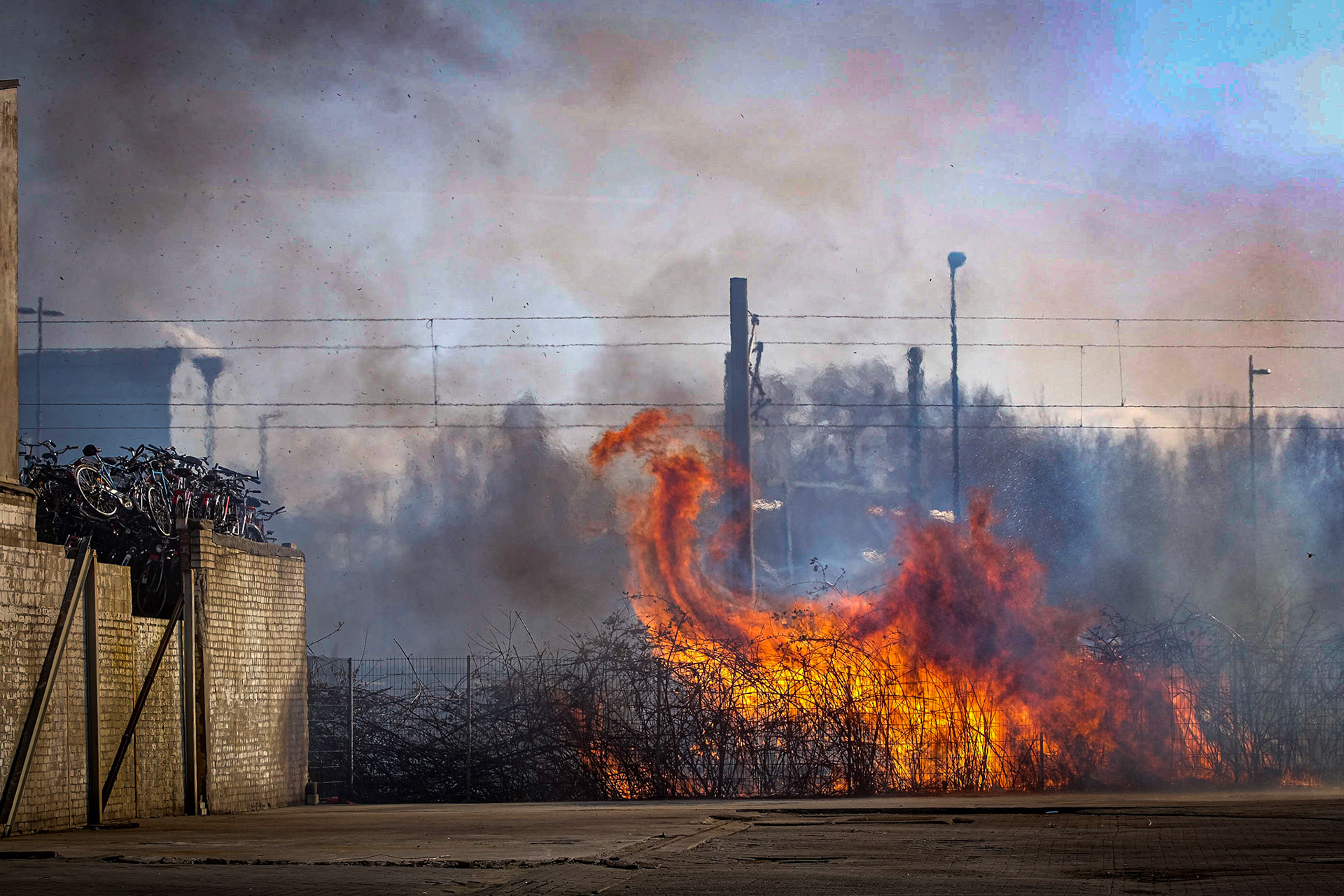 In einer Böschung neben den Bahngleisen an der Billstraße in Rothenburgsort ist am Dienstag gegen 16 Uhr ein Feuer am Bahndamm ausgebrochen. Die Flammen schlugen meterhoch aus dem Gebüsch und griffen auf einige Paletten auf einem Betriebsgelände daneben über. Man habe 3. Alarm ausgerufen und sei mit einem Großaufgebot angerückt. Auch eine Lagerhalle wurde durch den Brand etwas beschädigt. Erschwert wurden die Arbeiten aber durch die starke Rauchentwicklung.