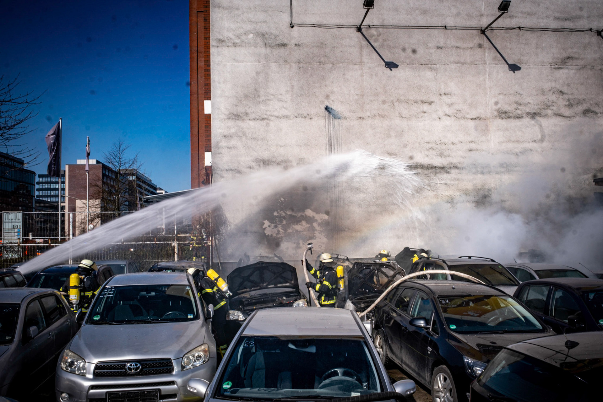 Es waren schreckliche Szenen am Freitagnachmittag in Hammerbrook. Ein Mann arbeitete am Heidenkampsweg auf dem Hof eines Autohändlers an einem Pkw. Plötzlich brach aus noch ungeklärter Ursache ein Feuer aus, der circa 45 Jahre alte Mann stand in Flammen und rannte auf die Straße. Schockierte Augenzeugen alarmierten um 12.28 Uhr die Feuerwehr. Als diese eintraf, um dem Mann zu helfen, war bereits 60 Prozent seiner Hautoberfläche verbrannt. Ein Notarzt stellte eine Verbrennung dritten Grades fest. Es besteht Lebensgefahr. Er wurde in das für Brandopfer spezialisierte Unfallkrankenhaus Boberg gebracht. Dort versucht man nun, sein Leben zu retten. Das Feuer bei dem voll besetzten Autohändler setzte insgesamt acht Pkw in Brand. Nach etwa 45 Minuten war das Feuer gelöscht. 45 Feuerwehrleute waren an dem Einsatz beteiligt. Der Rauchpilz war zwischenzeitlich bis zum Airbus-Standort auf Finkenwerder zu sehen. Während der Löscharbeiten richtete die Polizei stadteinwärts eine Vollsperrung des Heidenkampswegs an.
