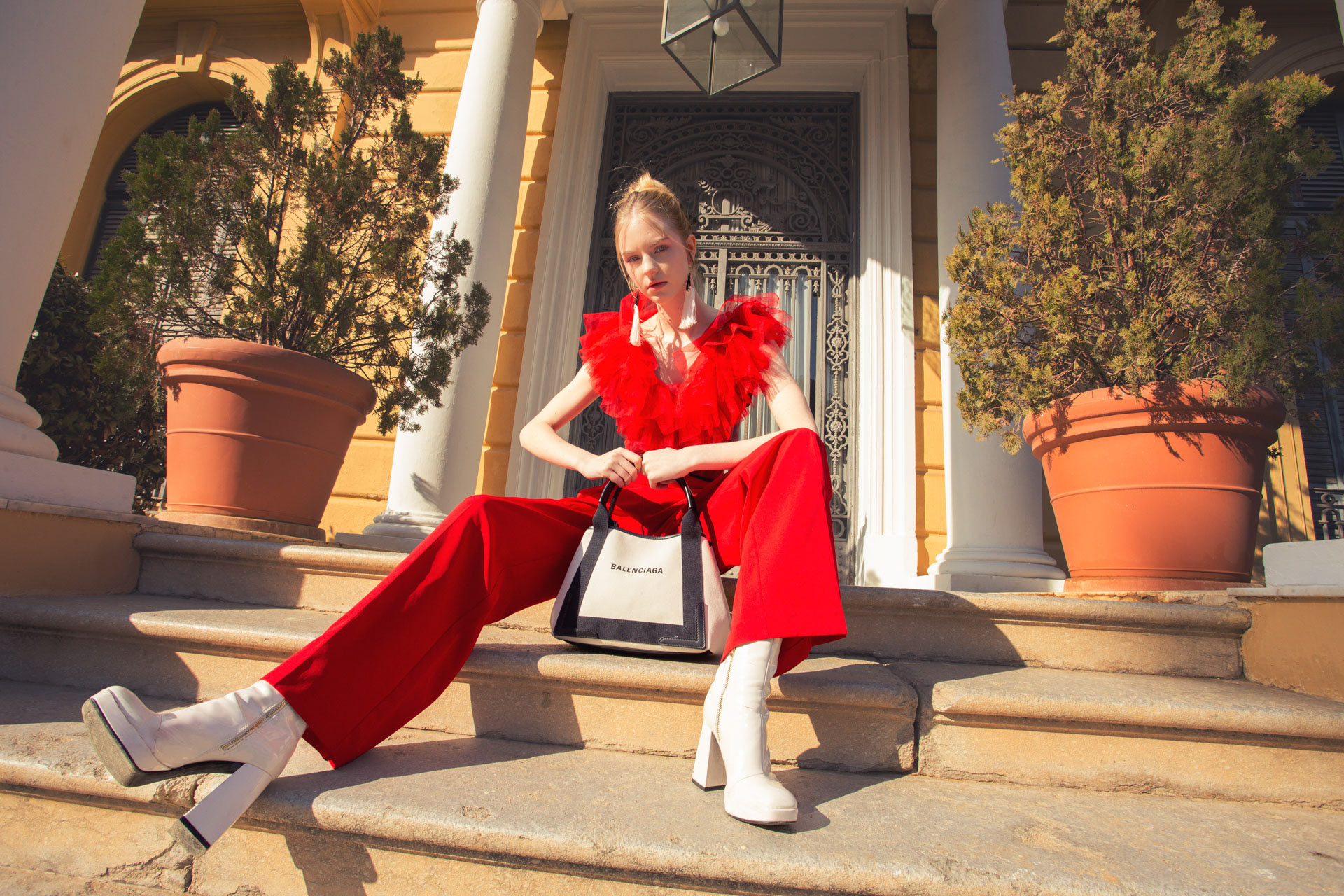 Model seated on the grass in a full multicolour ruffled skirt, Spring Charm, photographed by Alberto Branca