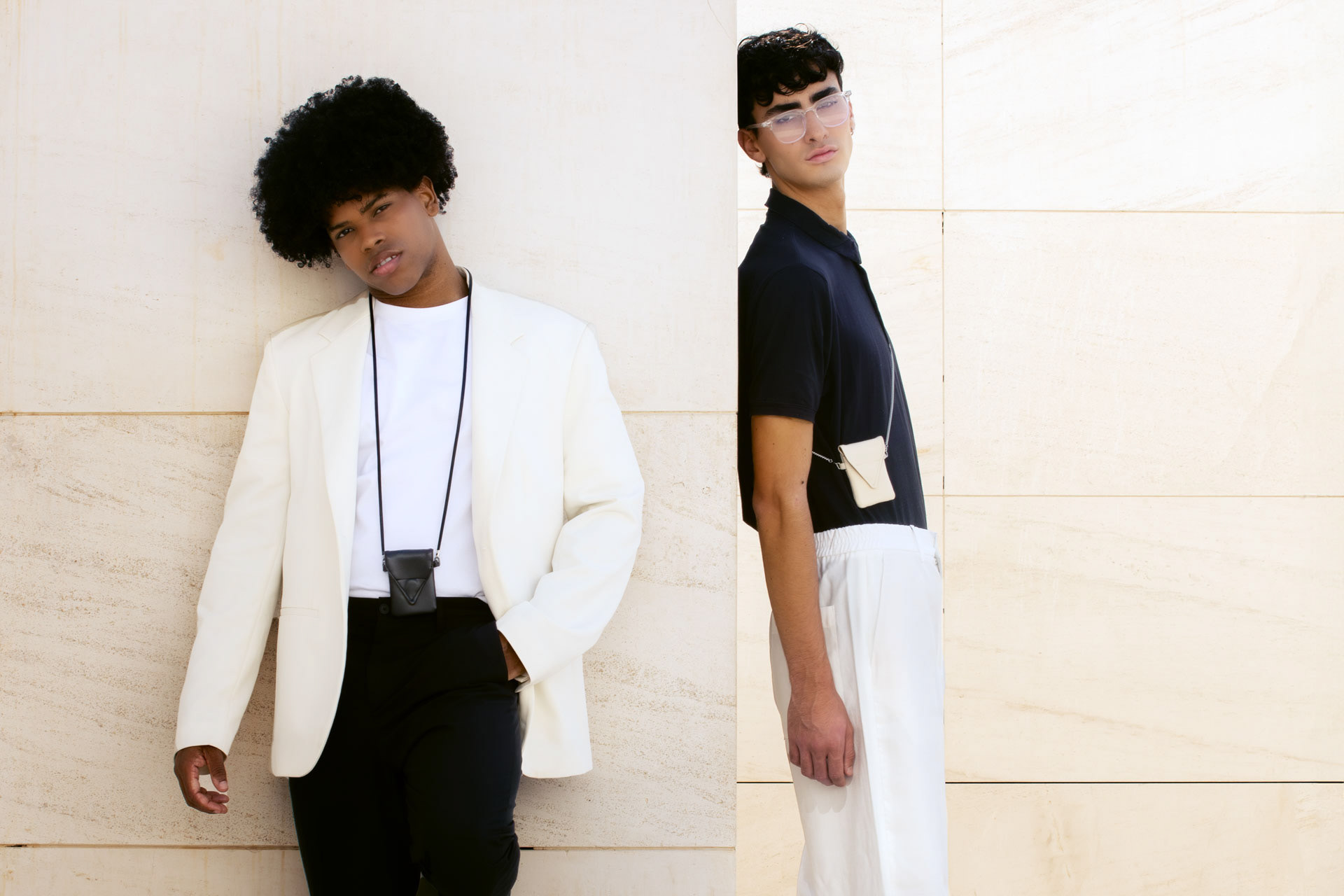 Two models against a travertine wall, each wearing a leather pocket pouch, My Pocket Pouch, photographed by Alberto Branca