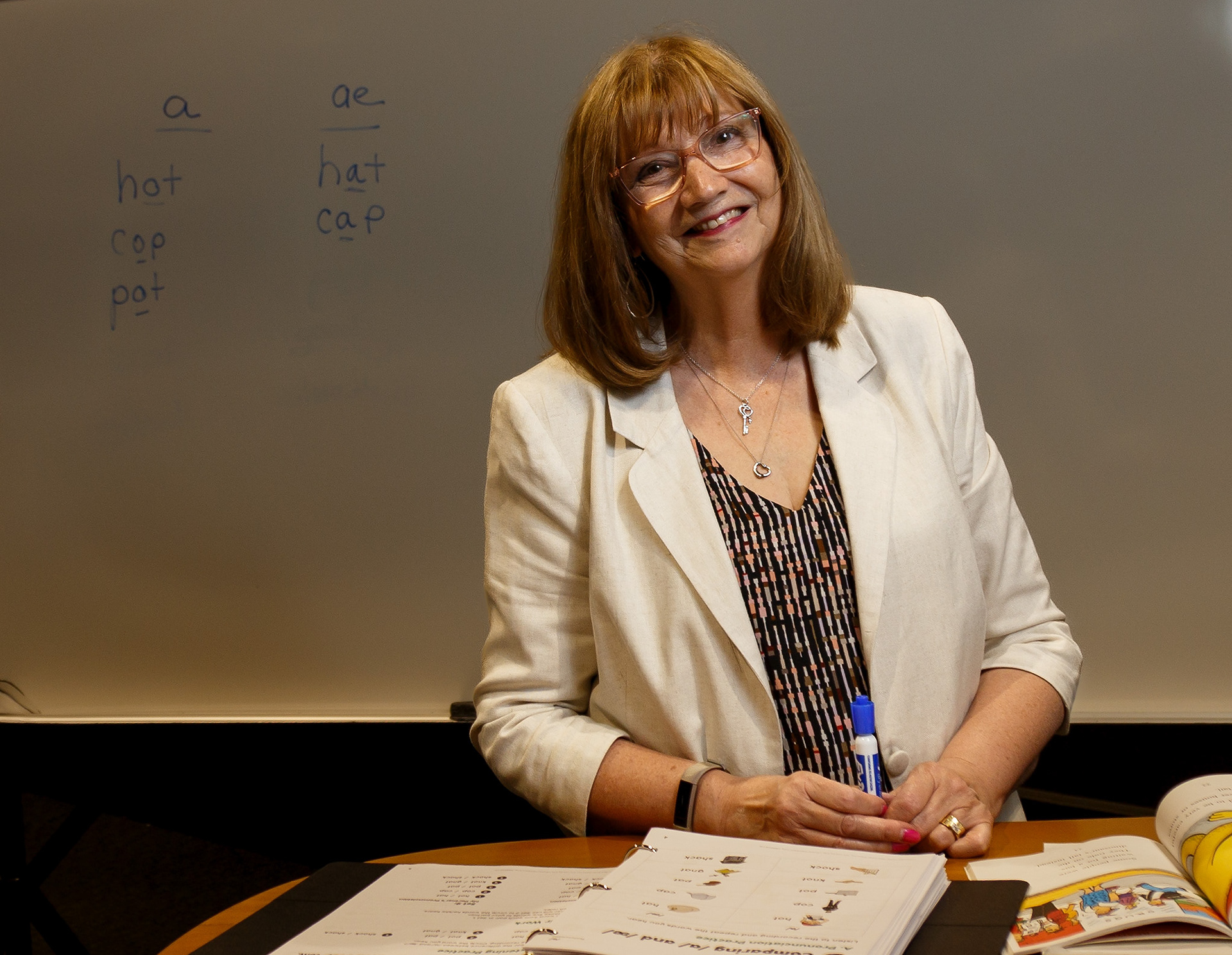 Jill Hopkins poses for a photo in the grade 5/6 room in First Alliance Church in Calgary on Friday, June 24, 2022. Hopkins teaches a group of adults ESL in this room during the school year. (Photo by Anna Burns/SAIT)