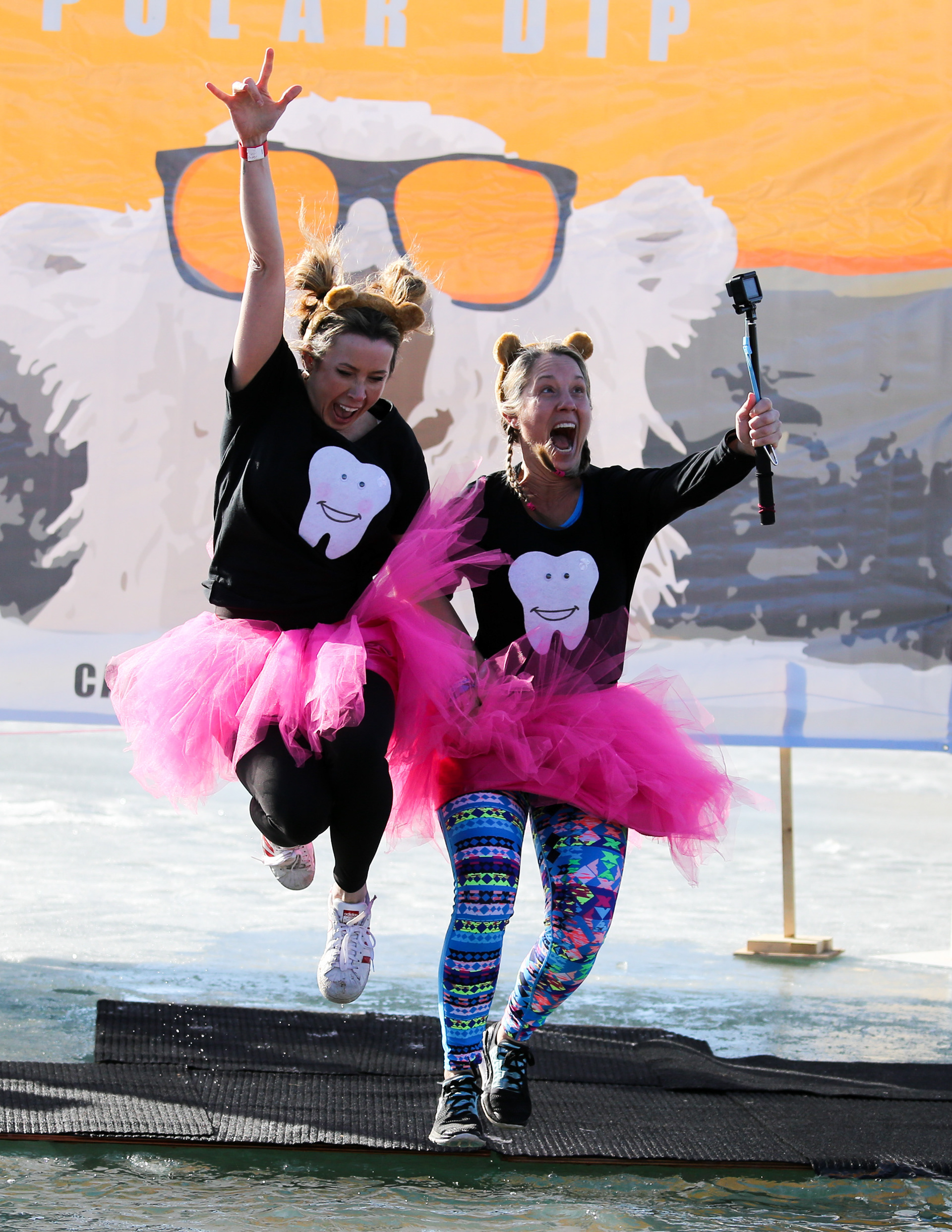 Two participants in the Calgary icebreaker polar dip jump into Lake Mahogany in Calgary on Saturday, Feb. 12, 2022. Participants in the event often dress up in a costume before taking a plunge in Lake Mahogany's frigid waters. The event is a fundraiser for the SA Foundation, an organization that helps fight human trafficking by providing safe, long-term housing and programs for affected women and children. The event reached their goal of raising $100, 000. 