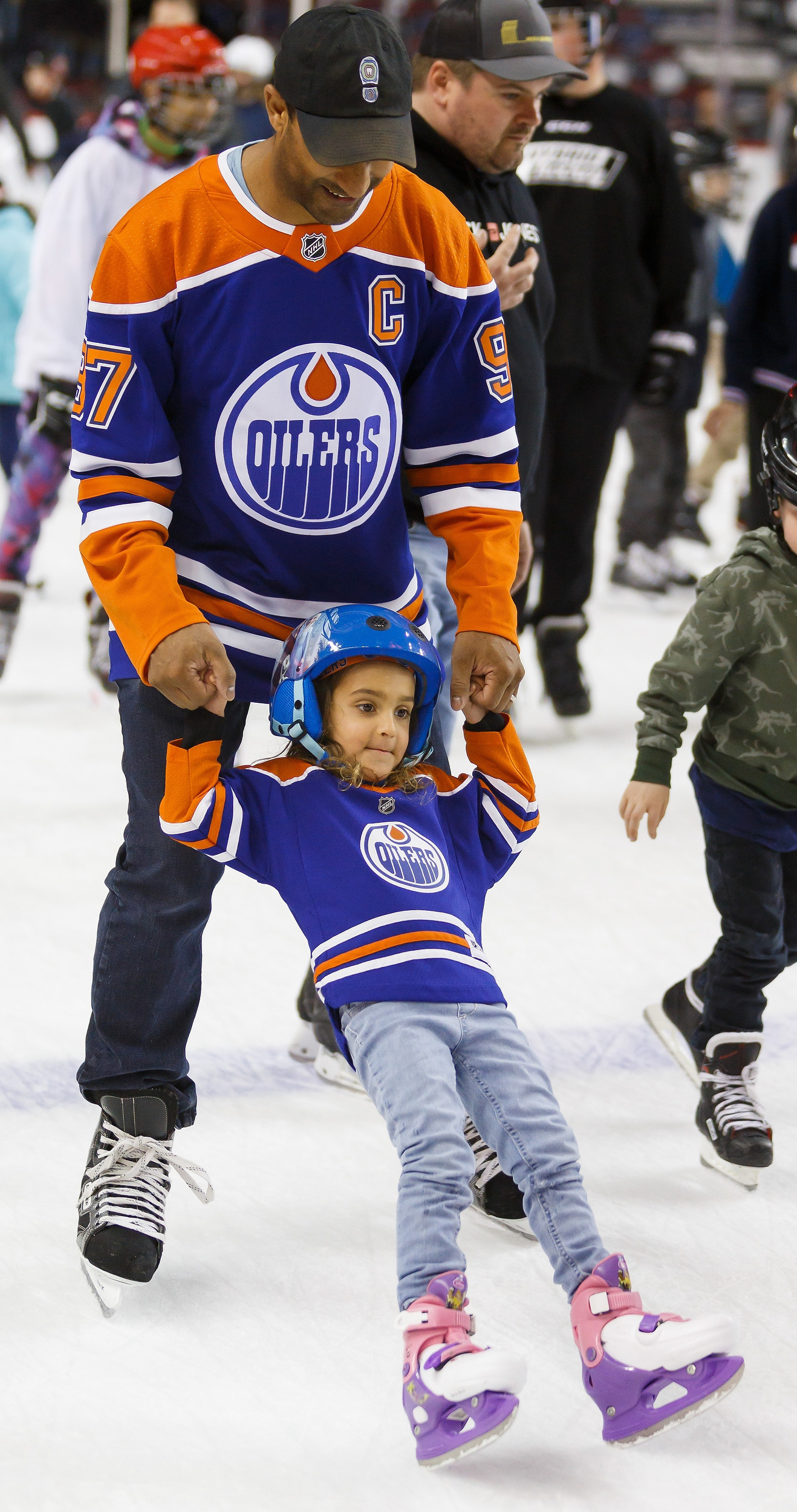 An adult holds up a young child as she starts to fall on the ice during the Ram Family Skate at the Scotiabank Saddledome Calgary on Sunday, April 10, 2022. Due to the pandemic, this is the first time this season they have had a family skate.