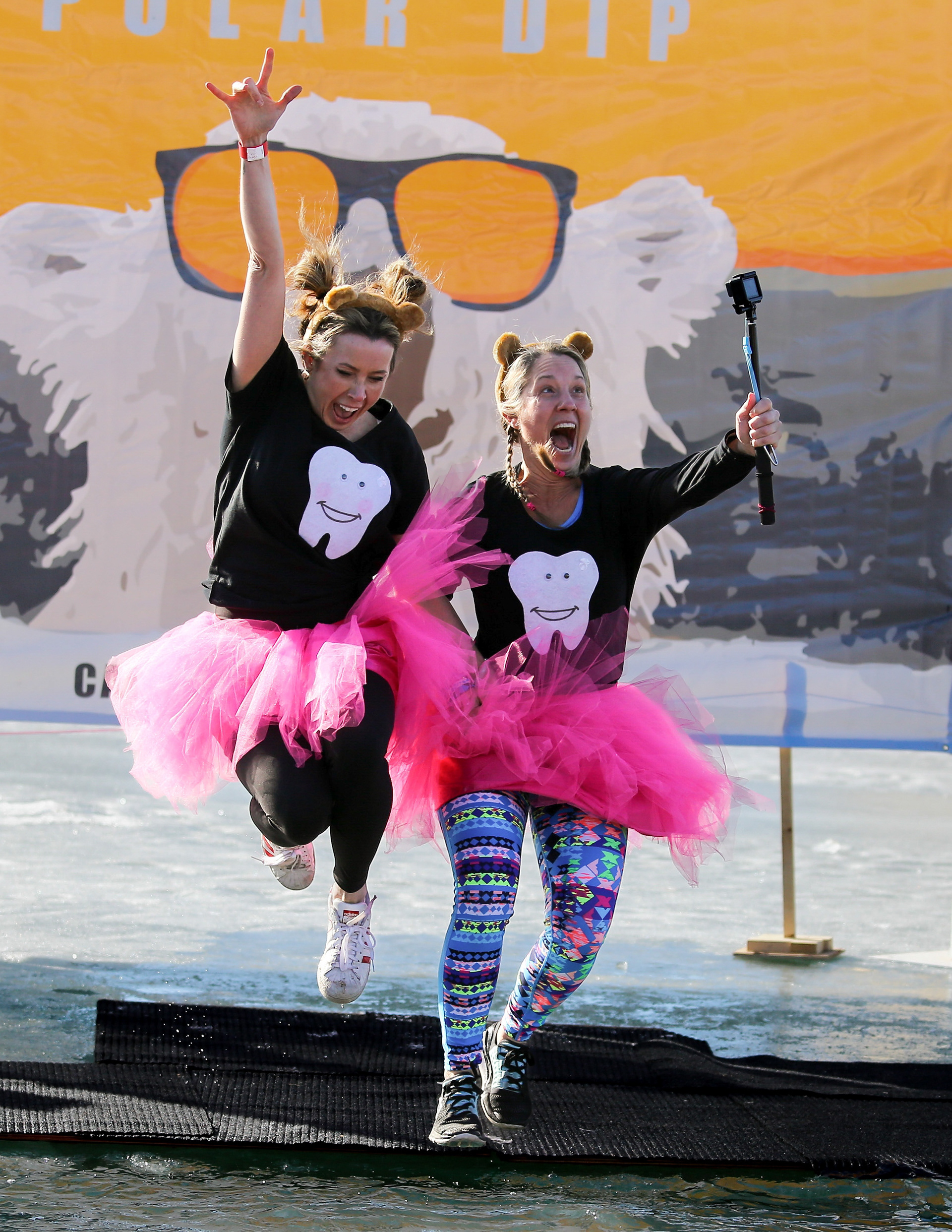 Two participants in the Calgary icebreaker polar dip jump into Lake Mahogany in Calgary on Saturday, Feb. 12, 2022. Participants in the event often dress up in a costume before taking a plunge in Lake Mahogany's frigid waters. The event is a fundraiser for the SA Foundation, an organization that helps fight human trafficking by providing safe, long-term housing and programs for affected women and children. The event reached their goal of raising $100, 000.