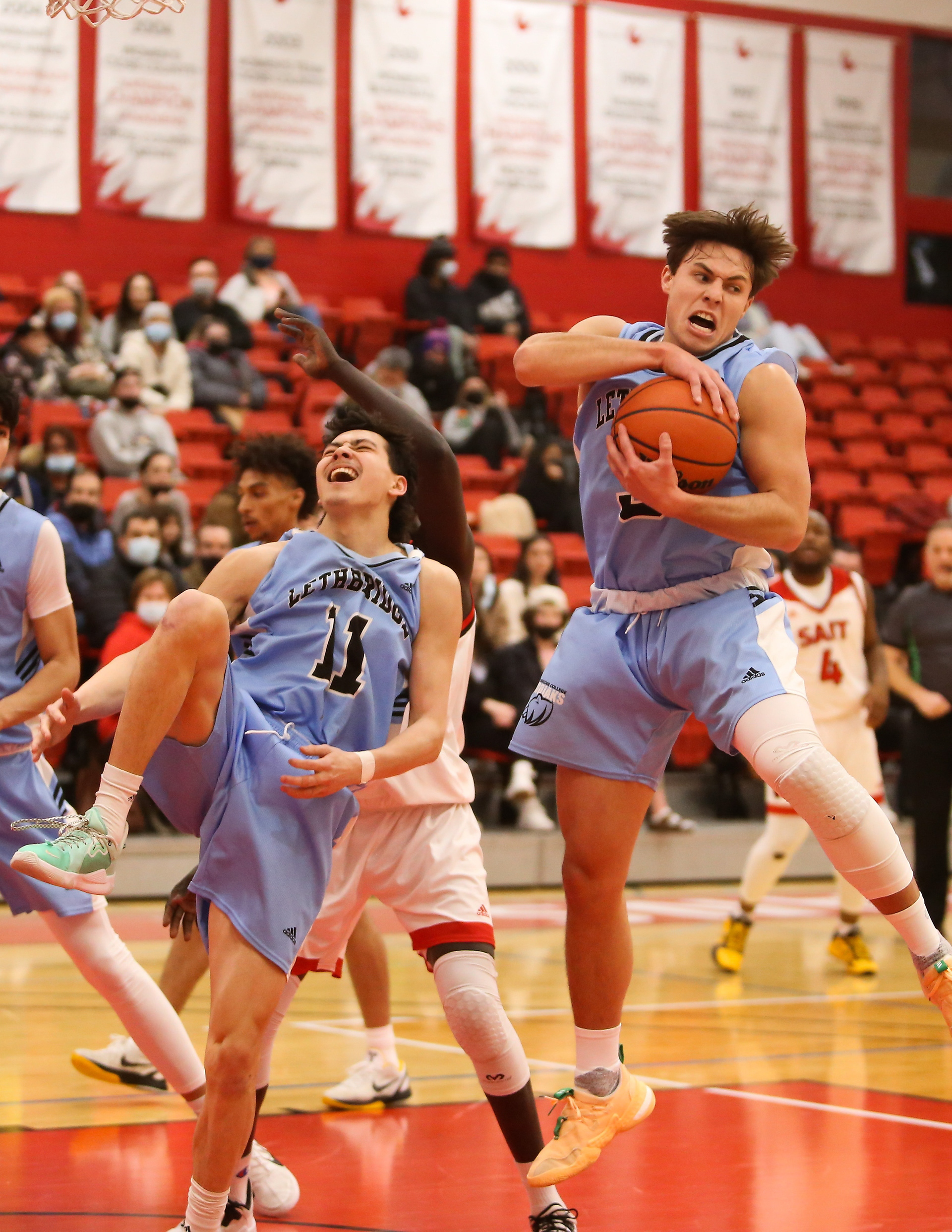 Guard Ty Lewis with Kodiaks grabs the ball, while his teammate guard Tomoya Owens grabs his ankle in pain at SAIT’s Campus Centre gym in Calgary on Saturday, Feb. 19, 2022. The Trojans defeated to the Kodiaks 69-68 during Alberta Colleges Athletic Conference regular season play. 