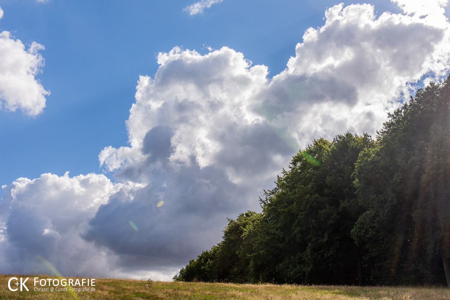Wolkenbildung und Sonnenstrahlen über einer Weide bei Bredeneek