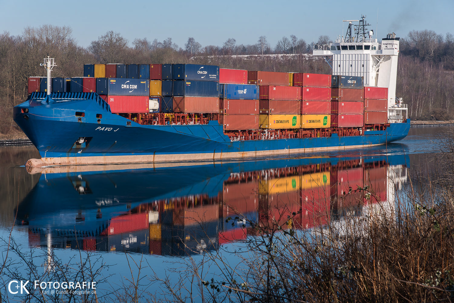 Containerschiff Pavo J spiegelt sich im Nord Ostsee Kanal