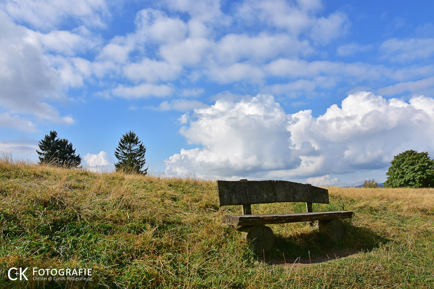 Landschaft in der Eifel mit Bank und Wolken