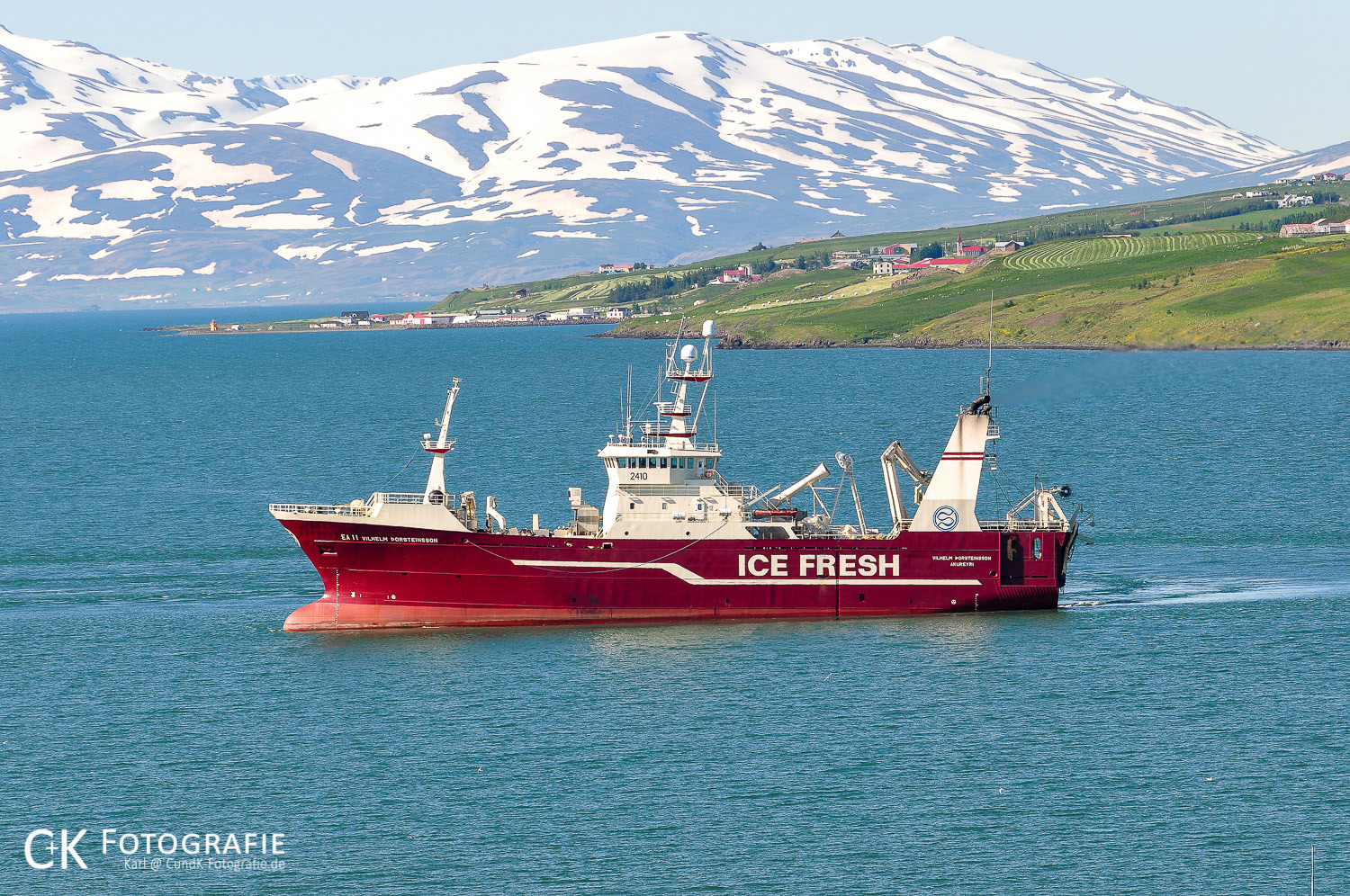 Fischkutter im Juni vor schneebedeckten Bergen bei Akureyri Island