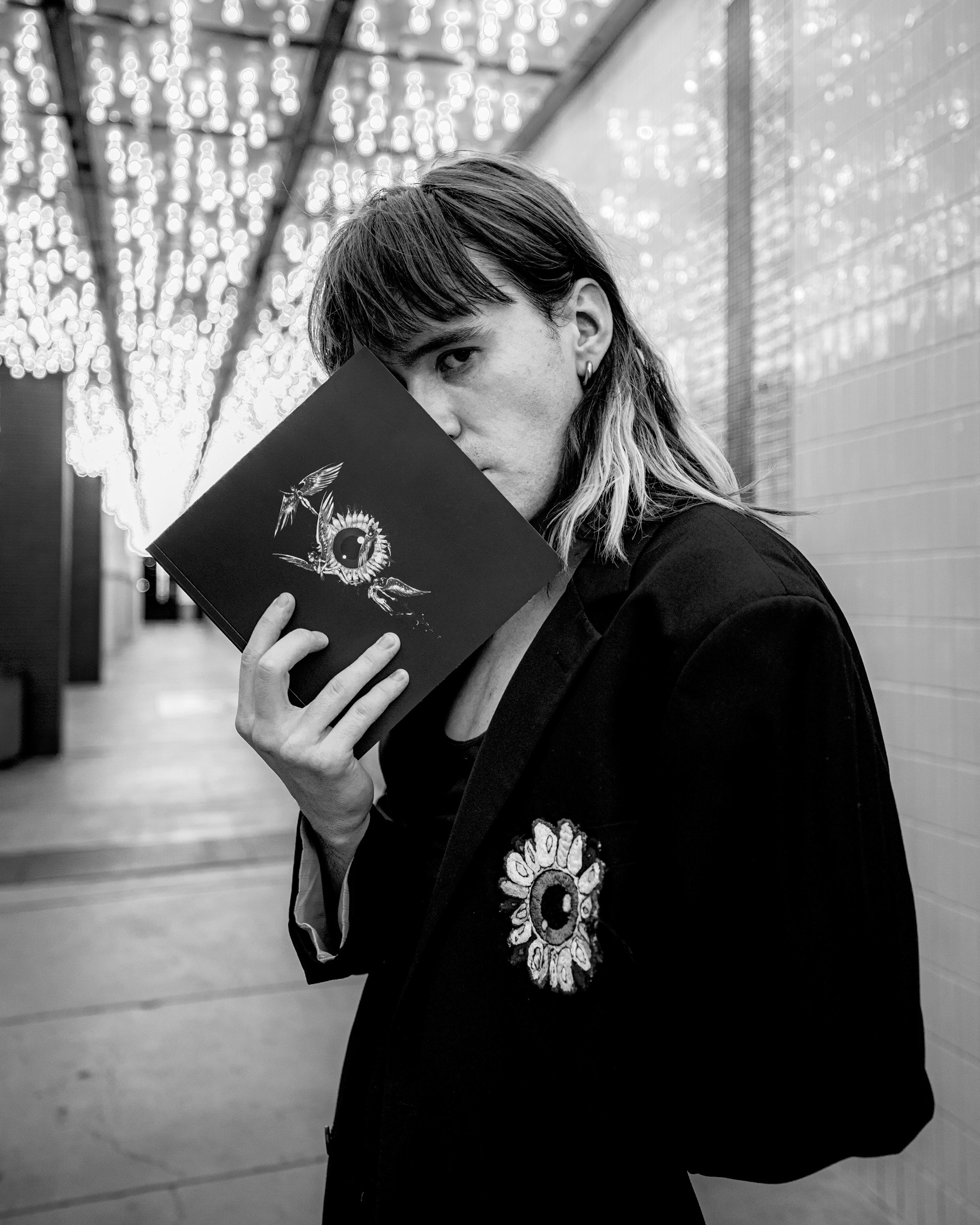 Ukrainian visual artist and painter Daniel Skripnik at the Plaza Hotel, Las Vegas. A black-and-white editorial portrait documenting the artist with his work amidst the high-contrast architecture of the Plaza corridor.