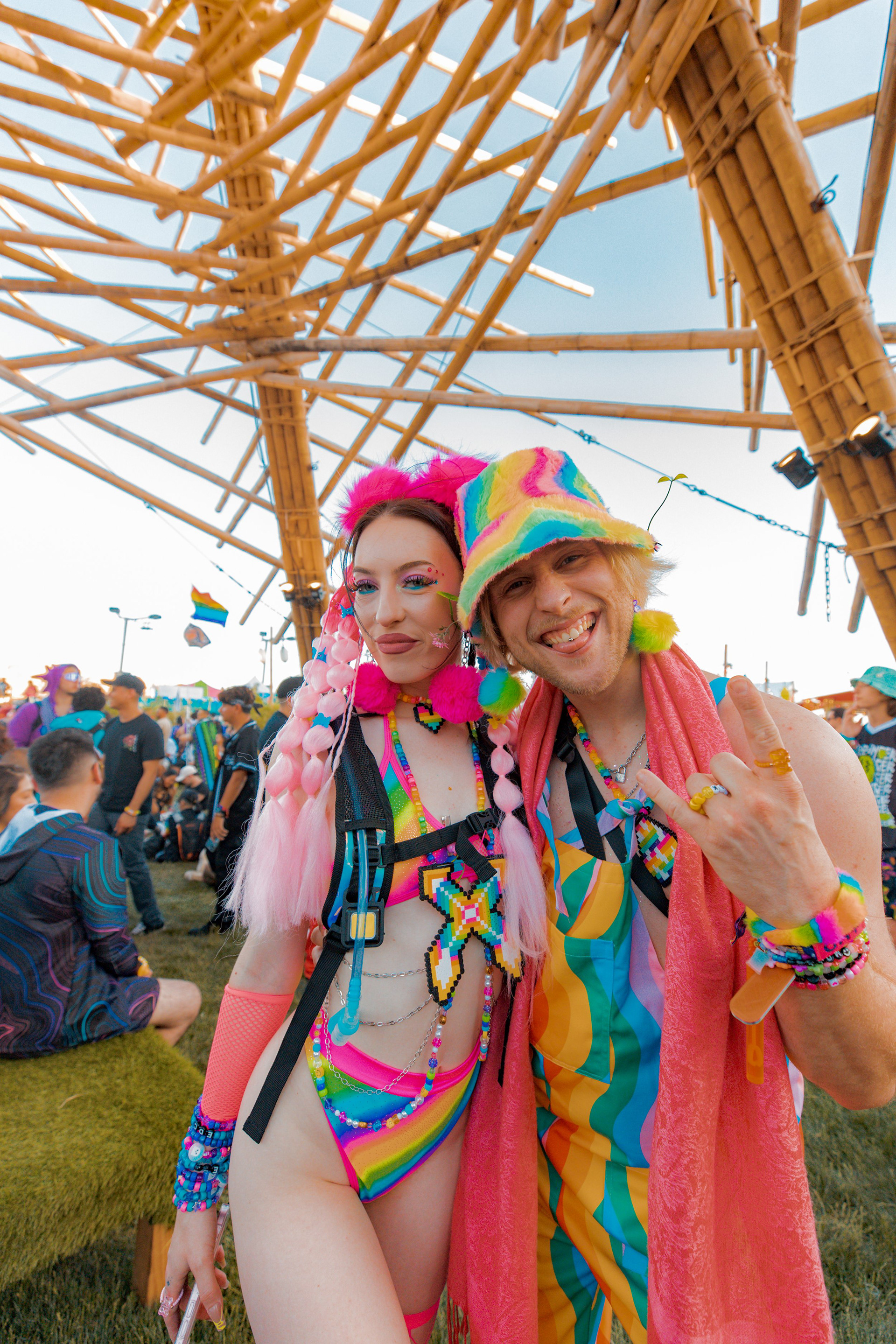 Capturing a duo portrait under the bamboo architectural structures. Documenting the intersection of festival art and fan culture at Electric Daisy Carnival.