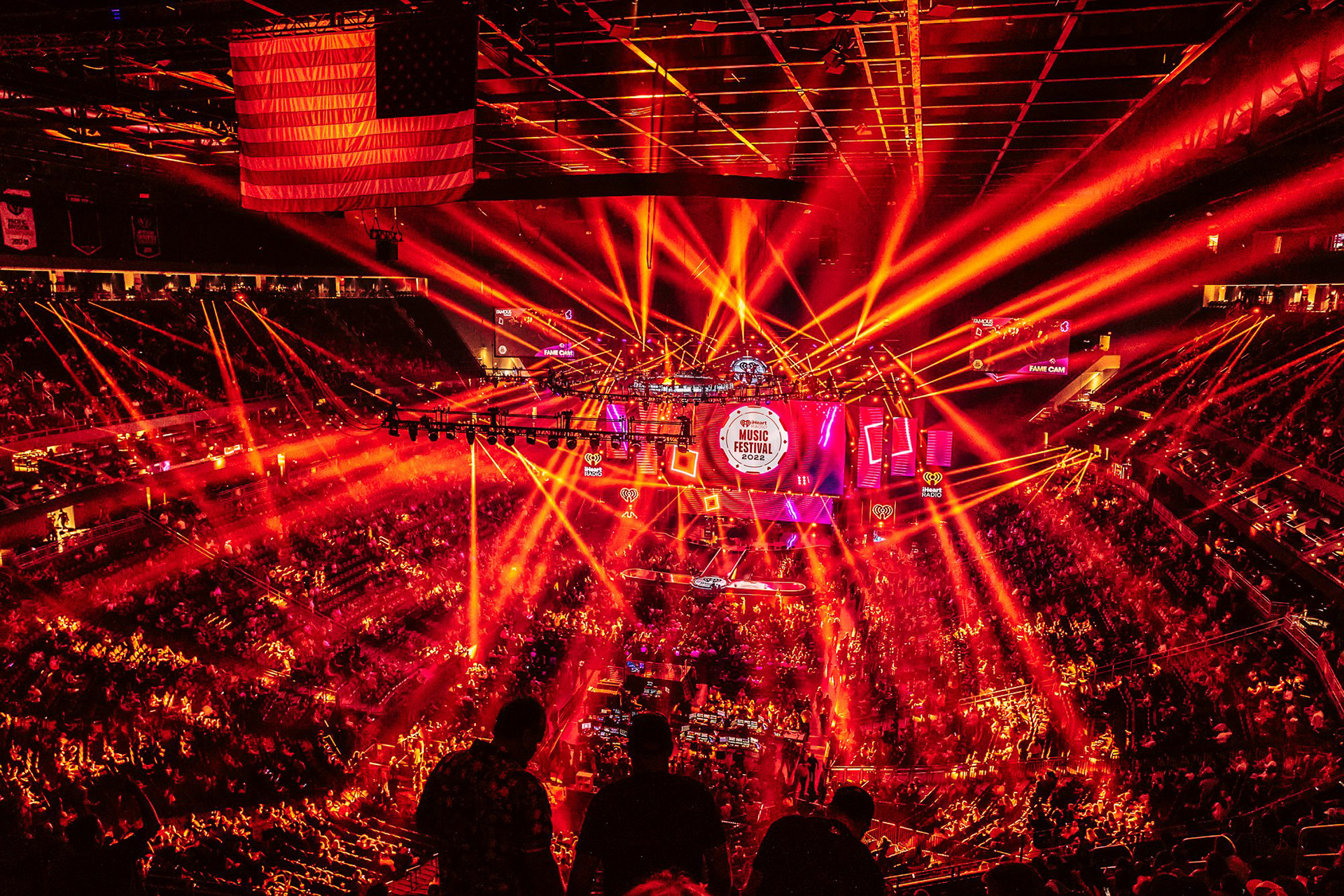 A crowd of 20,000 at T-Mobile Arena during the iHeartRadio Music Festival, highlighted by immersive lighting design and synchronized red lasers.