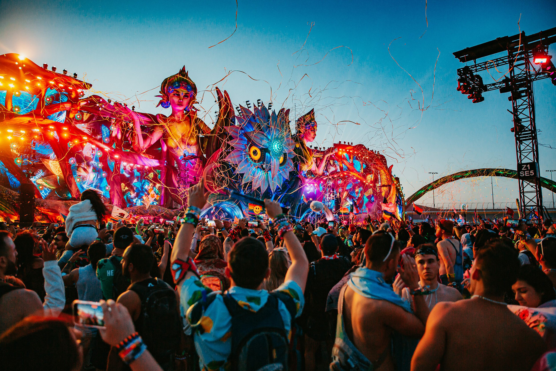 May 22, 2022 — A crowd gathered near a sunrise lit Kinetic Field stage as confetti fills the air during the Electric Daisy Carnival music festival at Las Vegas Motor Speedway in Las Vegas, Nevada.