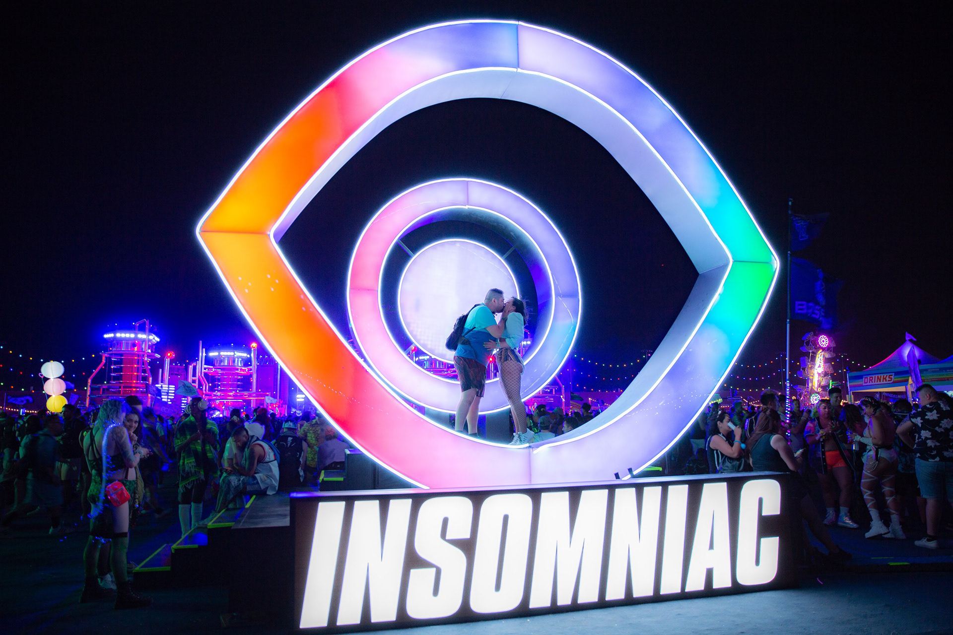 "Love Under the Electric Sky: EDC Las Vegas. An atmospheric portrait of connection and scale atop the Insomniac festival architecture at the Las Vegas Motor Speedway.