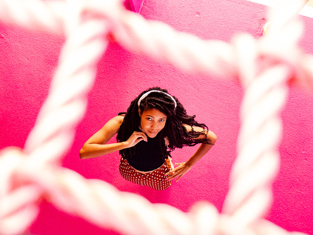 Color-theory and composition: Nicole Stephens captured in Miami. A lifestyle portrait utilizing architectural textures and a vibrant pink palette for a high-contrast, modern aesthetic.