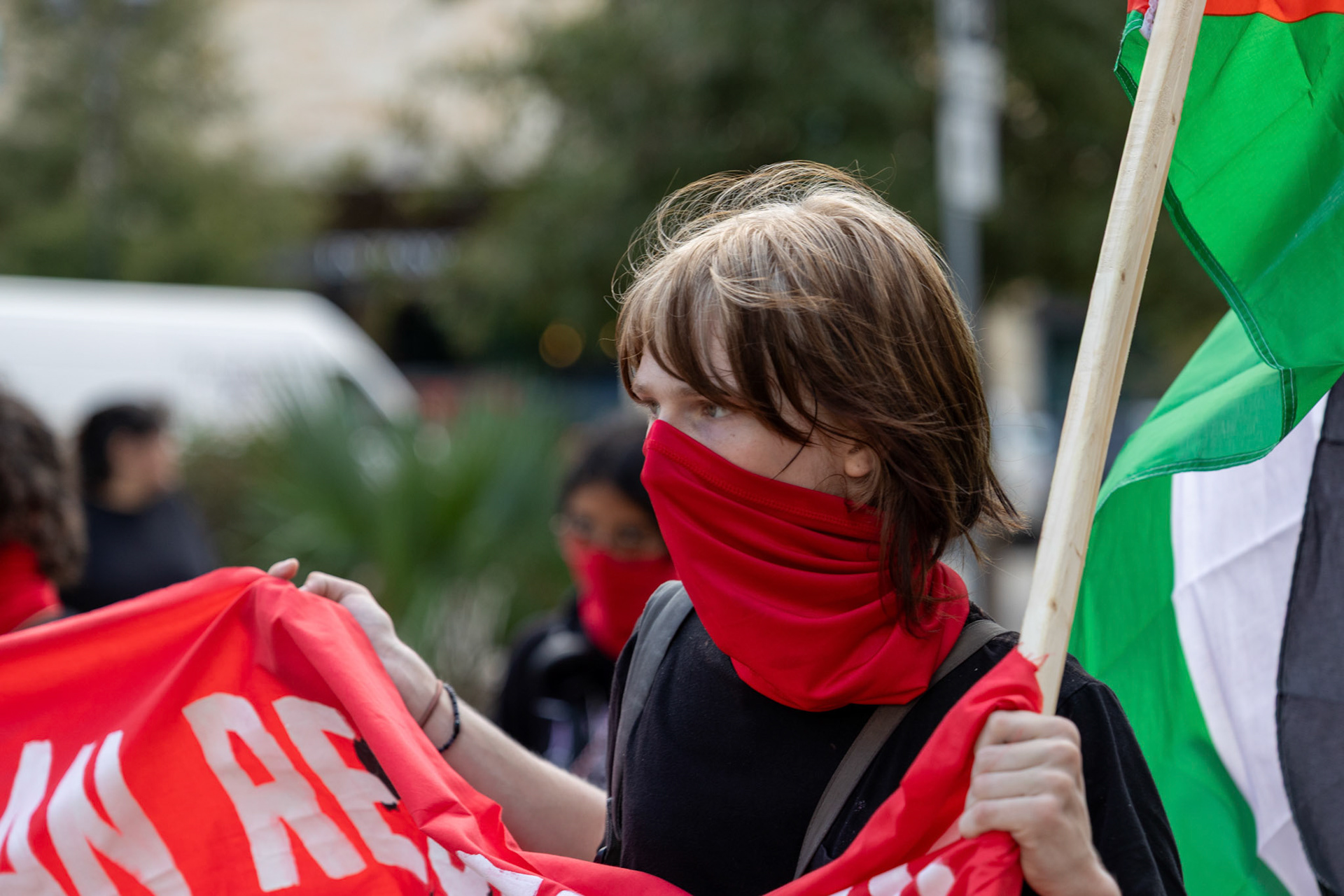 A member of the Fox Tech Student League, who requested to remain anonymous, holds a banner and a Palestinian flag during a planned walkout protest on Oct. 7, 2025, in San Antonio.