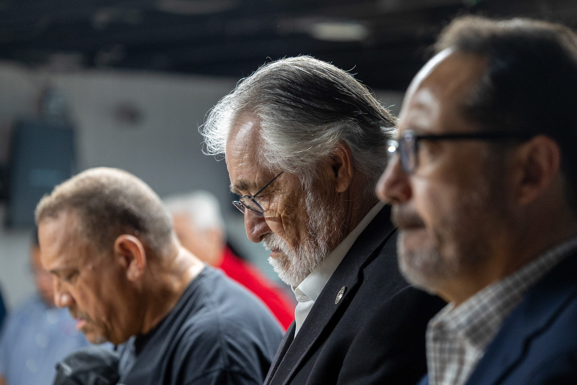 State Rep. Ray Lopez, D-San Antonio, bows his head in prayer next to state Sen. José Menéndez, D-San Antonio, during the third annual Memorial Flag Ceremony honoring Texas Veteran Suicide Prevention Day on Monday at VFW Post 76.